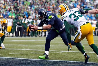 SEATTLE, WA - JANUARY 18:  Russell Wilson #3 of the Seattle Seahawks runs the ball in for a touchdown as  Micah Hyde #33 of the Green Bay Packers closes in during the fourth quarter of the 2015 NFC Championship game at CenturyLink Field on January 18, 201