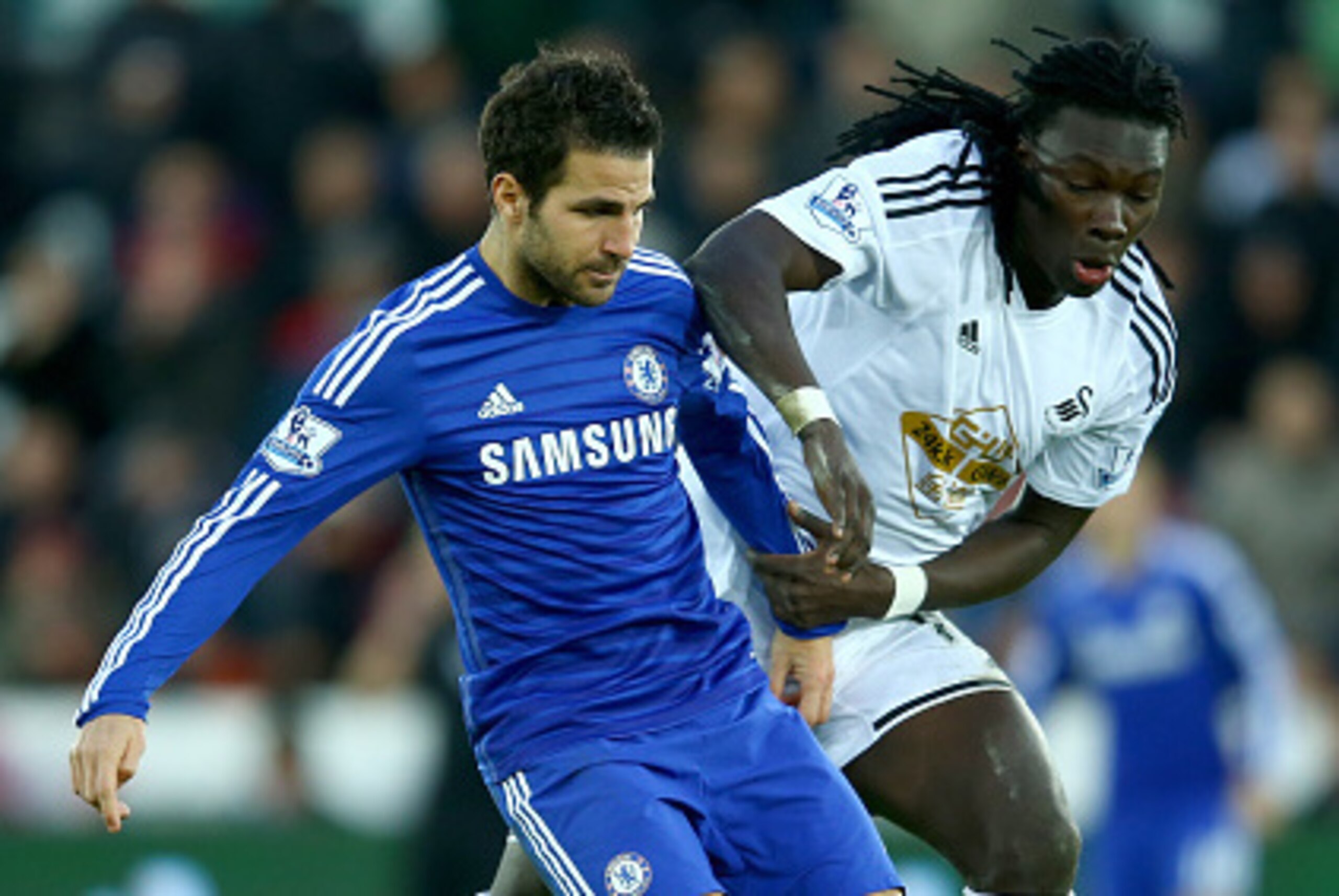 SWANSEA, WALES - JANUARY 17:  Cesc Fabregas of Chelsea holds off  Marvin Emnes of Swansea during the Barclays Premier League match between Swansea City and Chelsea at the Liberty Stadium on January 17, 2015 in Swansea, Wales.  (Photo by Richard Heathcote/