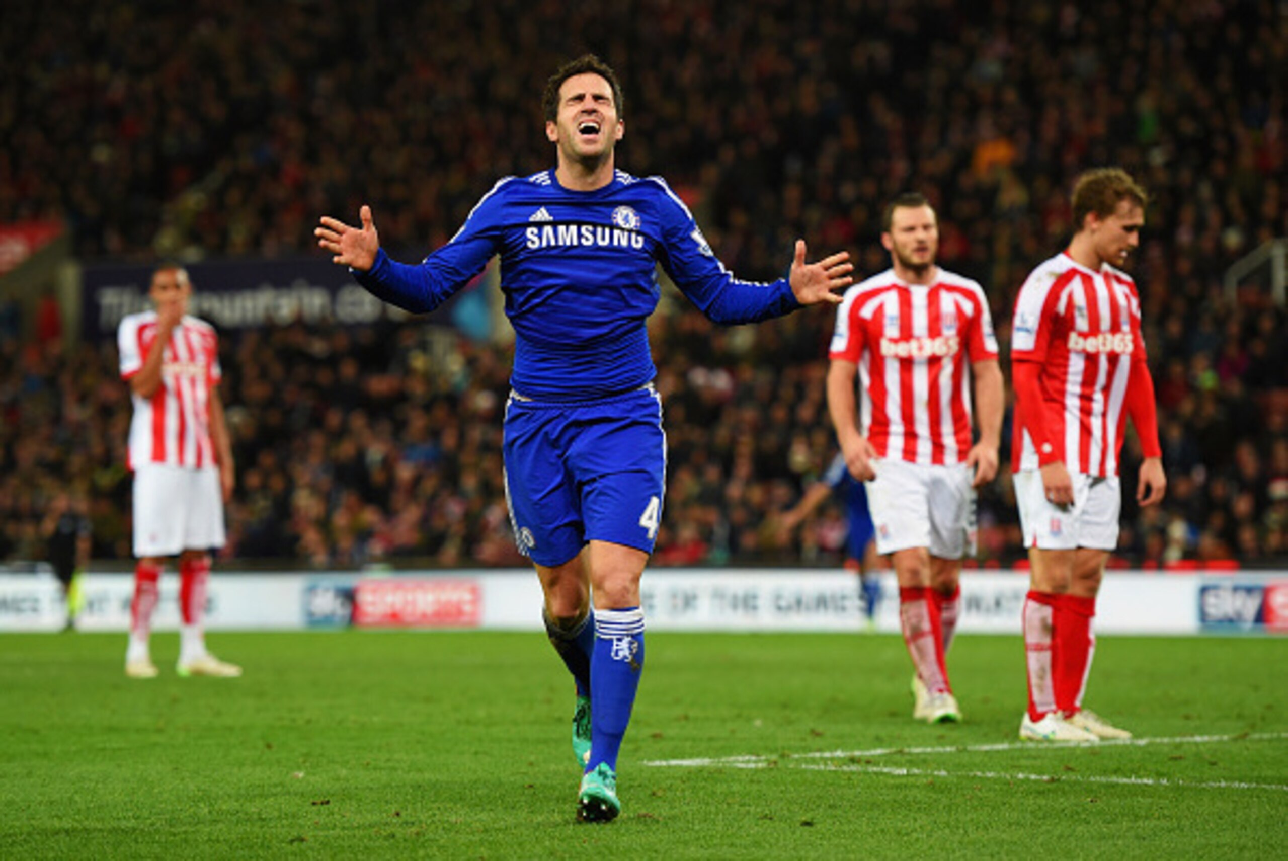 STOKE ON TRENT, ENGLAND - DECEMBER 22:  Stoke City players look dejected as Cesc Fabregas of Chelsea celebrates as he scores their second goal during the Barclays Premier League match between Stoke City and Chelsea at Britannia Stadium on December 22, 201