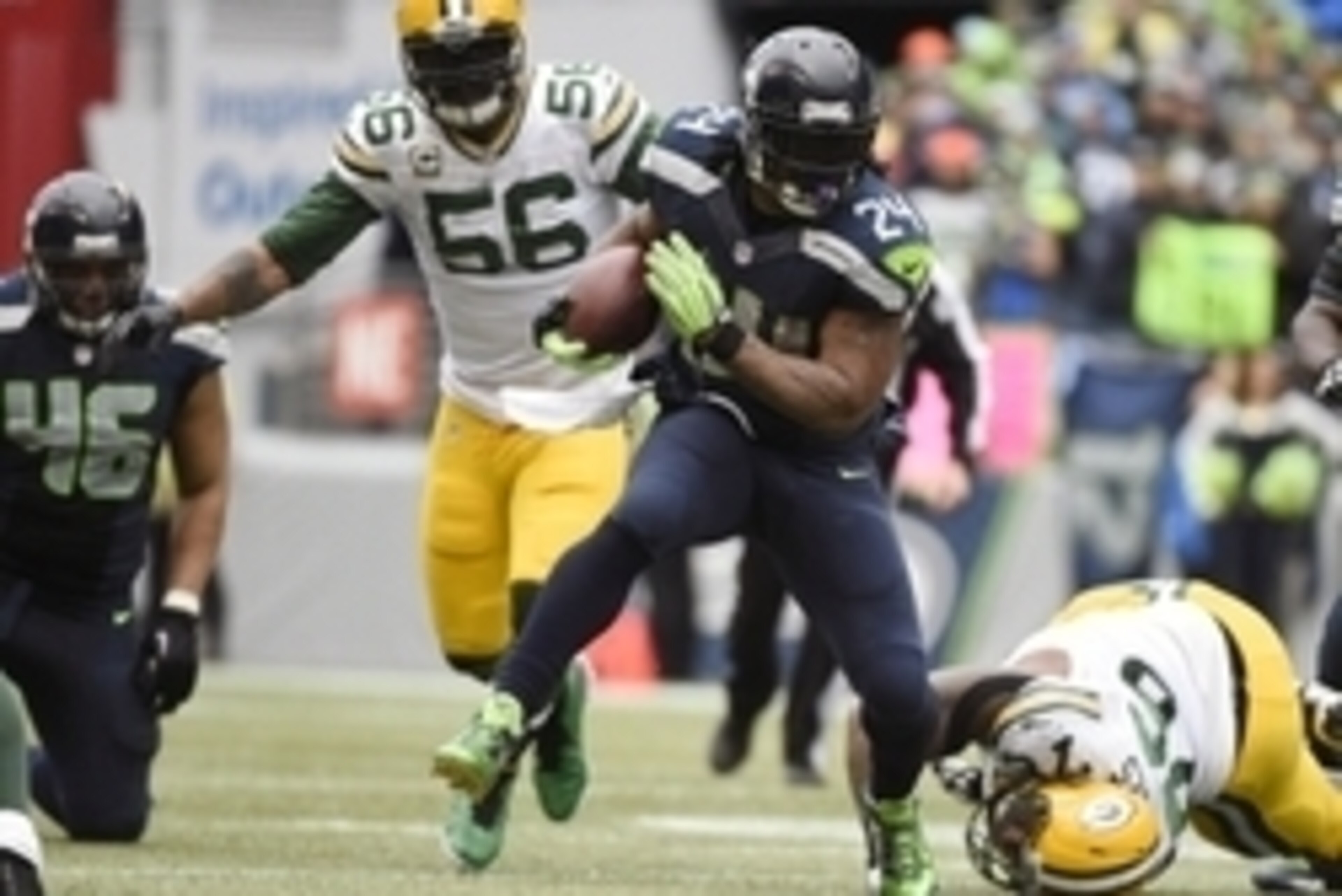 January 18, 2015; Seattle, WA, USA; Seattle Seahawks running back Marshawn Lynch (24) runs the ball ahead of  Green Bay Packers outside linebacker Julius Peppers (56) and defensive end Mike Daniels (76) during the second half in the NFC Championship game 