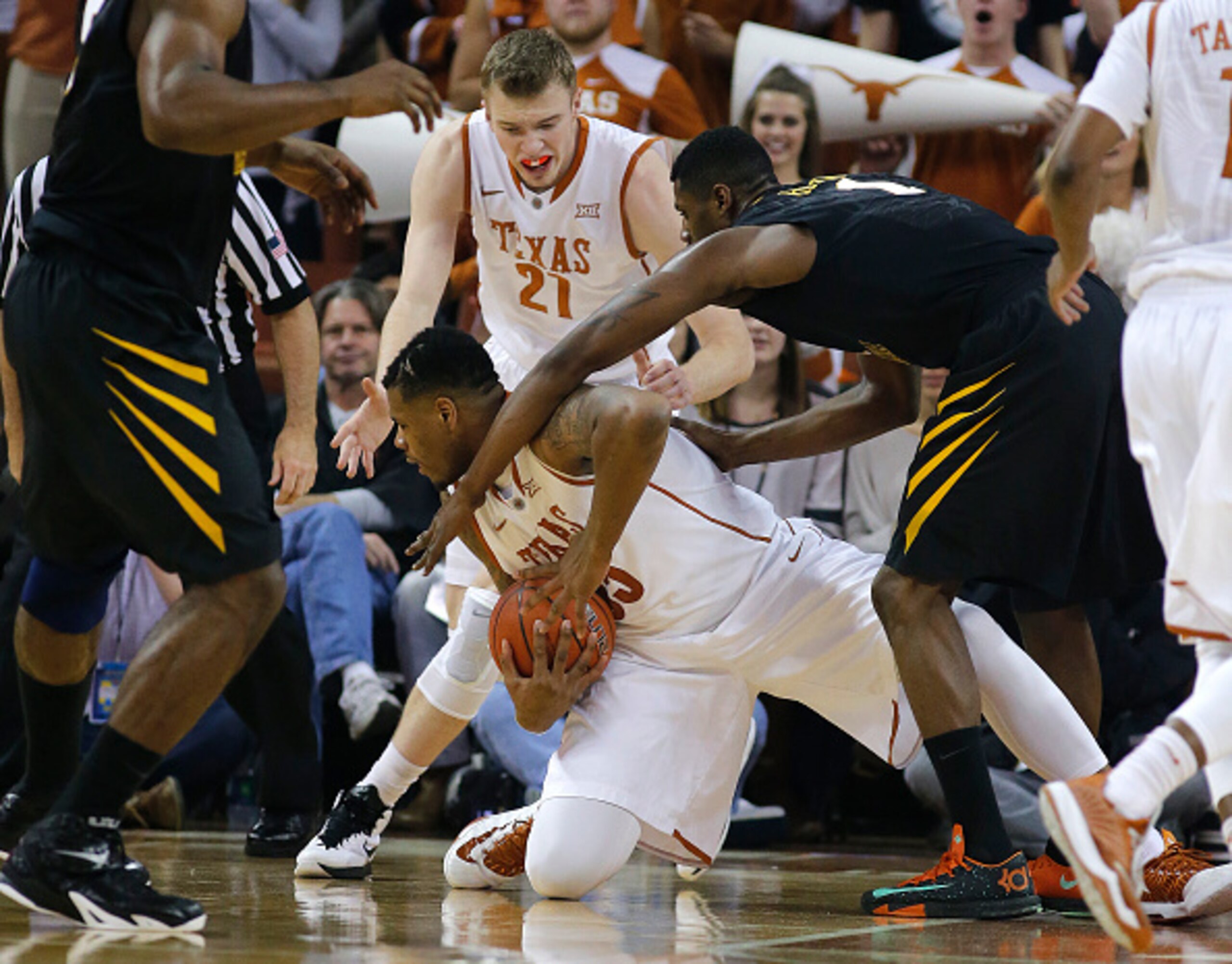 AUSTIN, TX - JANUARY 17: Cameron Ridley #55 of the Texas Longhorns battles for a loose ball with Jonathan Holton #1 of the West Virginia Mountaineers at the Frank Erwin Center on January 17, 2015 in Austin, Texas. (Photo by Chris Covatta/Getty Images)