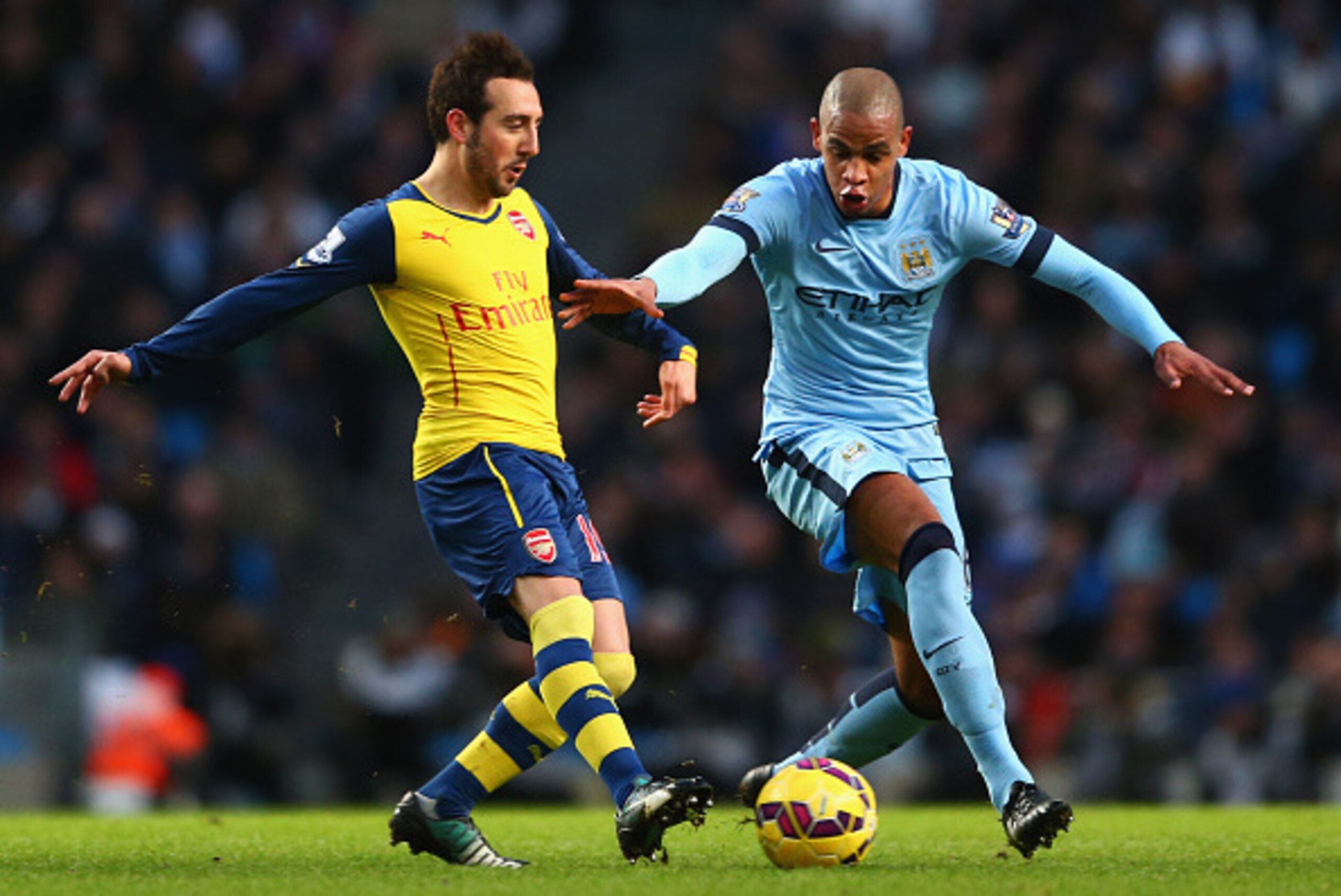 MANCHESTER, ENGLAND - JANUARY 18:  Santi Cazorla of Arsenal is tracked by Fernando of Manchester City during the Barclays Premier League match between Manchester City and Arsenal at Etihad Stadium on January 18, 2015 in Manchester, England.  (Photo by Mic