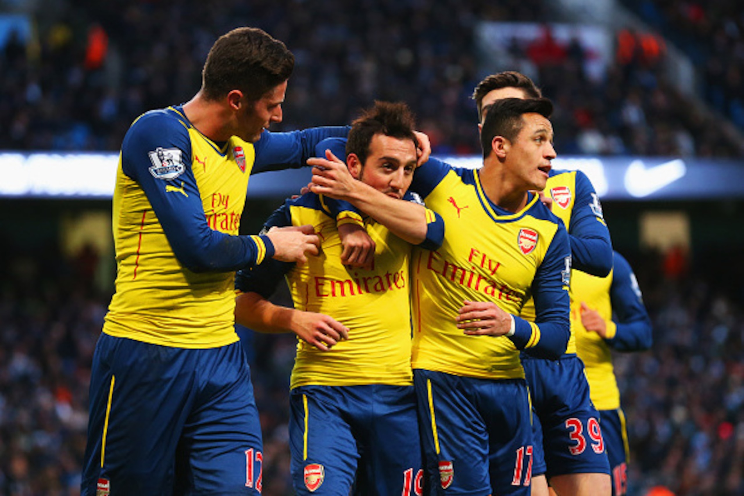 MANCHESTER, ENGLAND - JANUARY 18:  Santi Cazorla of Arsenal (2L) celebrates with team mates as he scores their first goal from a penalty during the Barclays Premier League match between Manchester City and Arsenal at Etihad Stadium on January 18, 2015 in 