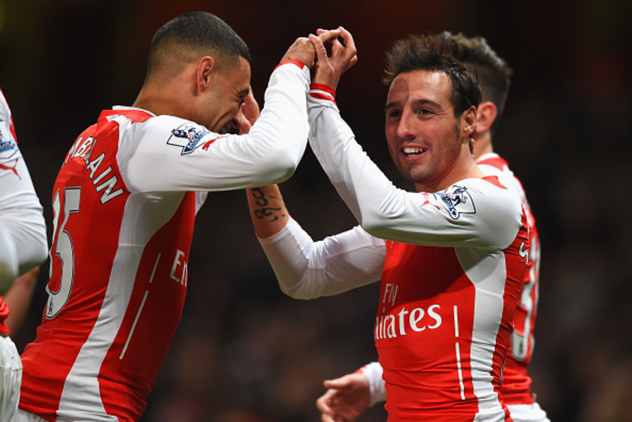 LONDON, ENGLAND - DECEMBER 13:  Santi Cazorla of Arsenal celebrates scoring his team's second goal with Alex Oxlade-Chamberlain during the Barclays Premier League match between Arsenal and Newcastle United at Emirates Stadium on December 13, 2014 in Londo