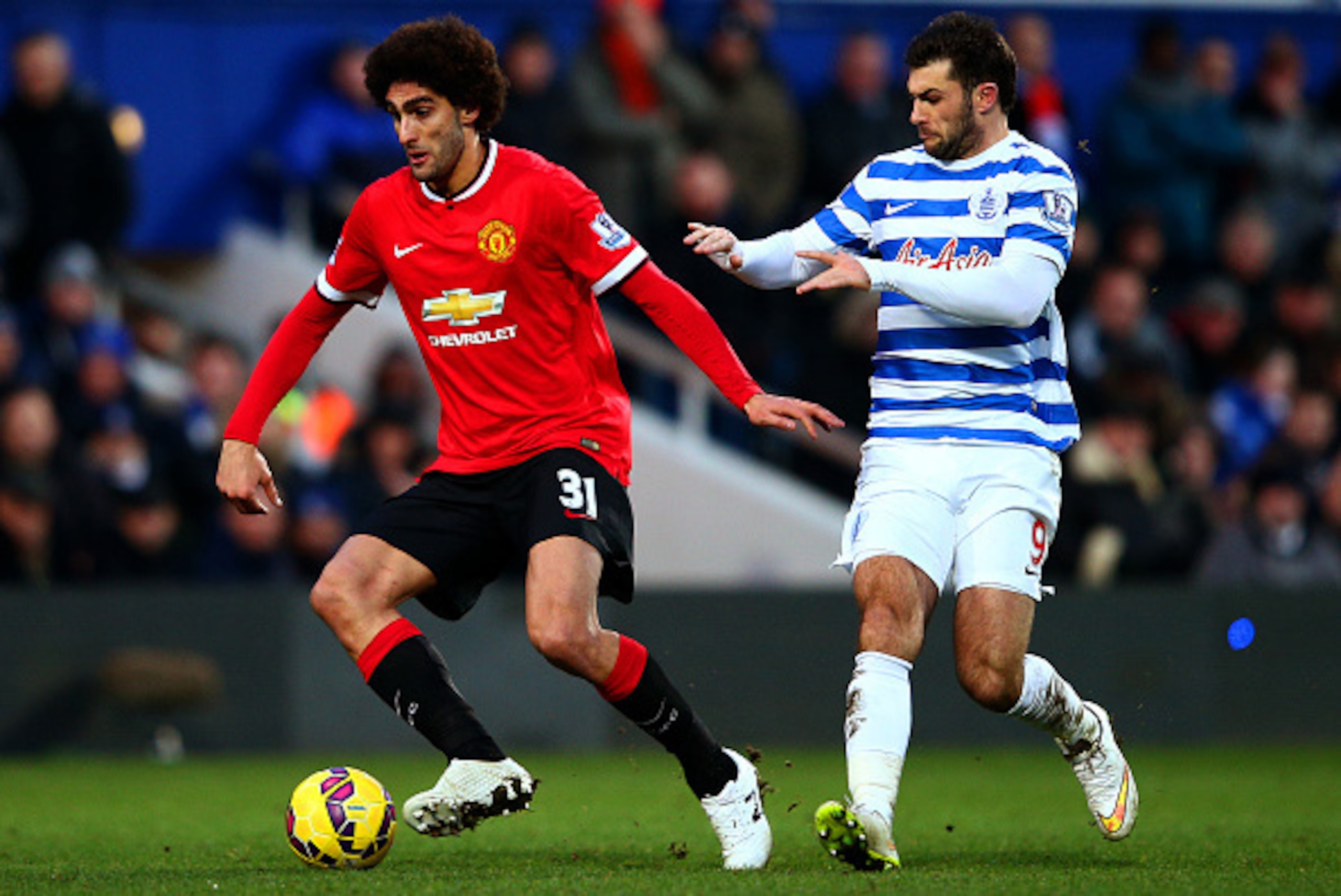 LONDON, ENGLAND - JANUARY 17:  Marouane Fellaini of Manchester United shields the ball from Charlie Austin of QPR during the Barclays Premier League match between Queens Park Rangers and Manchester United at Loftus Road on January 17, 2015 in London, Engl