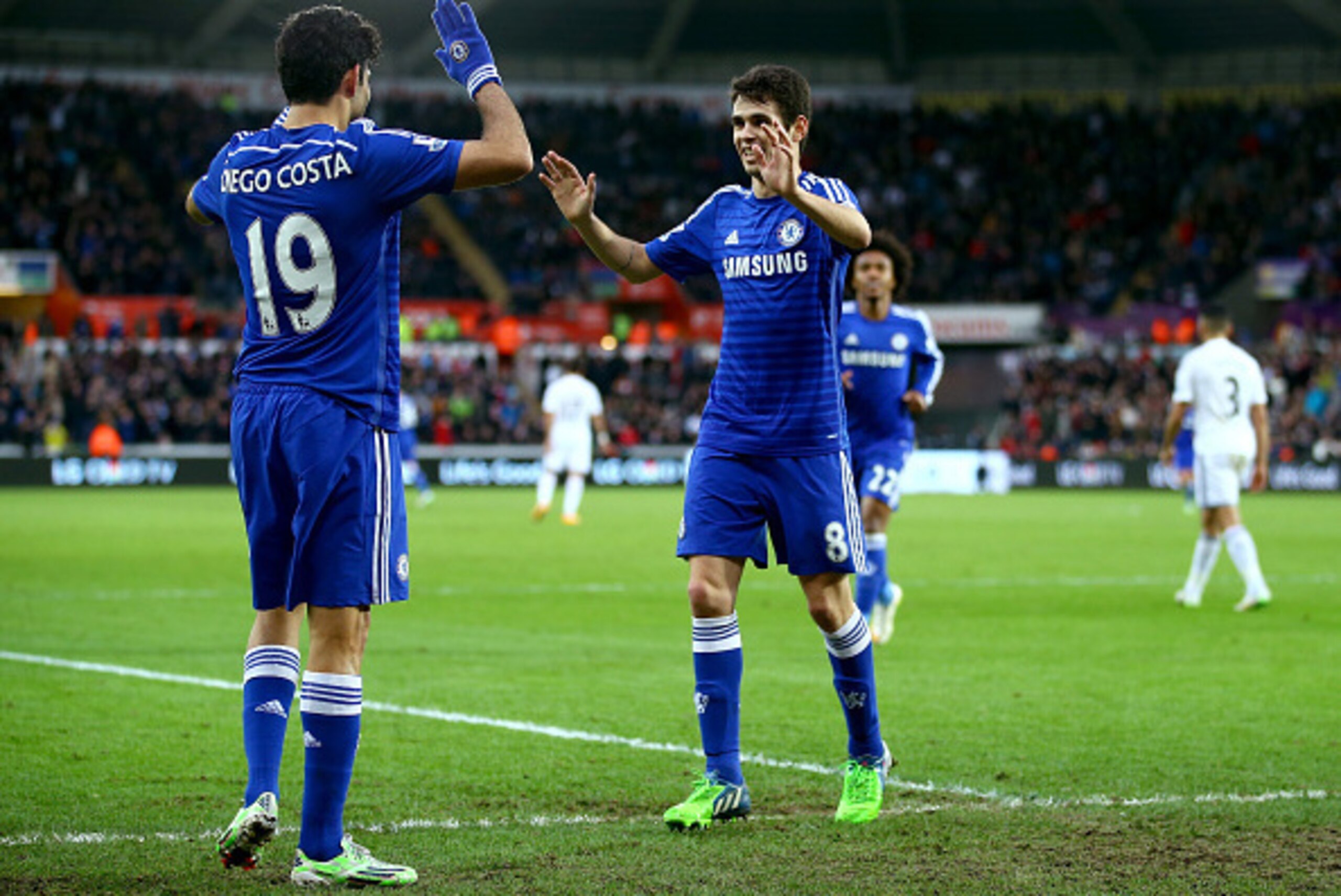 SWANSEA, WALES - JANUARY 17:  Oscar of Chelsea celebrates with Diego Costa of Chelsea after scoring his team's fourth goal during the Barclays Premier League match between Swansea City and Chelsea at Liberty Stadium on January 17, 2015 in Swansea, Wales. 