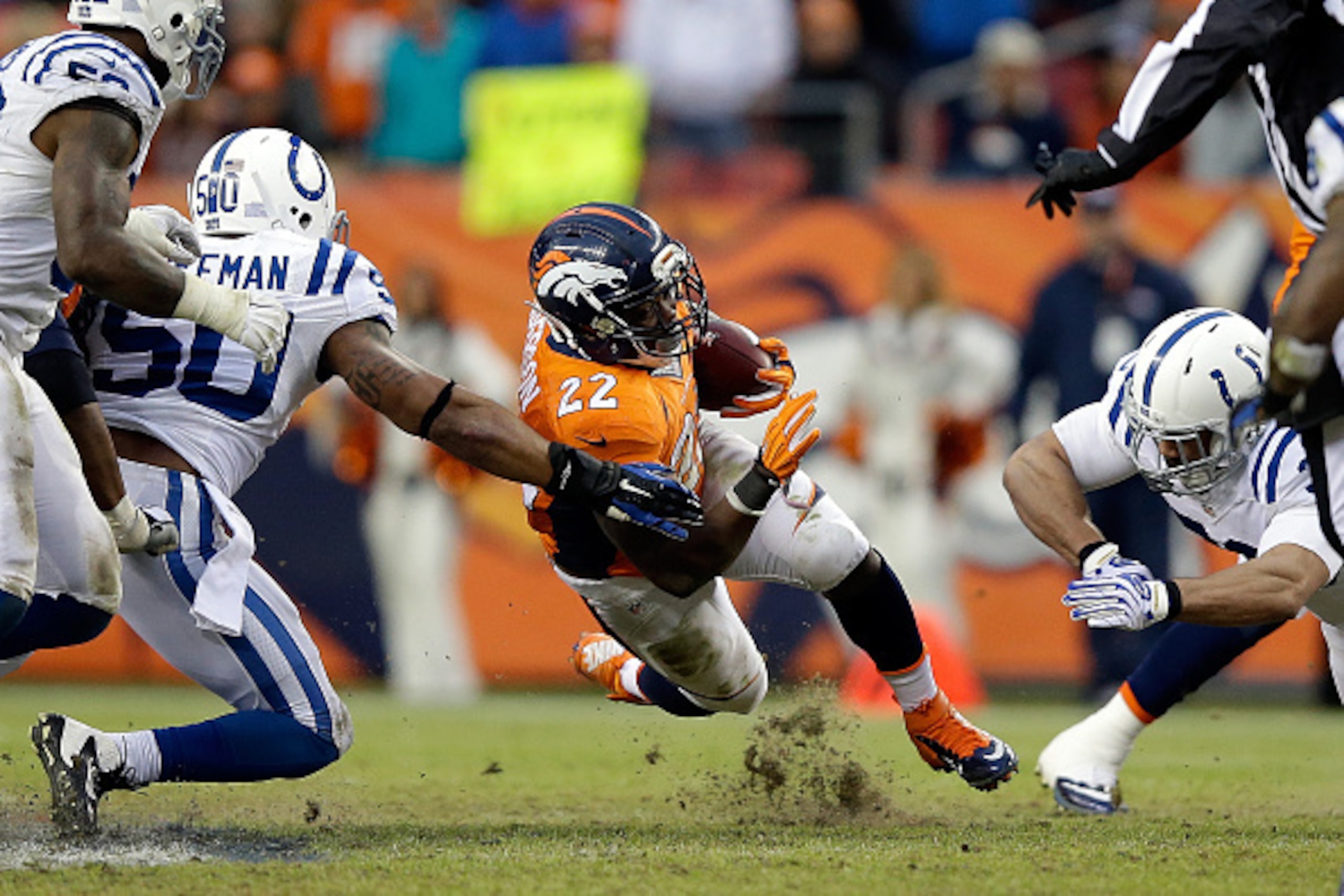 DENVER, CO - JANUARY 11:  C.J. Anderson #22 of the Denver Broncos carries the ball as Jerrell Freeman #50 of the Indianapolis Colts defends during a 2015 AFC Divisional Playoff game at Sports Authority Field at Mile High on January 11, 2015 in Denver, Col