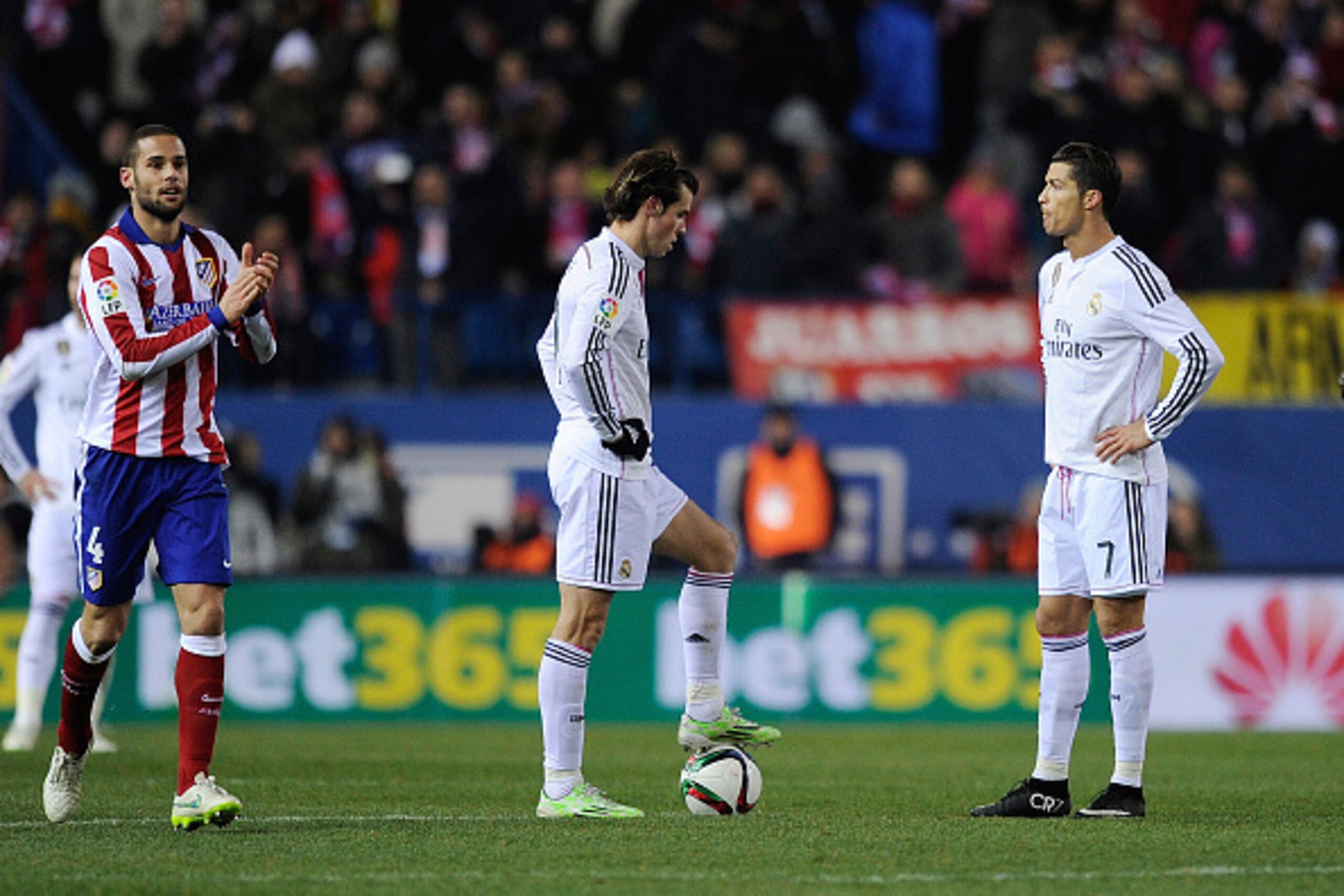 MADRID, SPAIN - JANUARY 07:  Cristiano Ronaldo and Gareth Bale of Real Madrid get ready to kick the ball beside Mario Suarez of Club Atletico de Madrid after Club Atletico de Madrid scored their 2nd goal  during the Copa del Rey Round of 16, First Leg mat