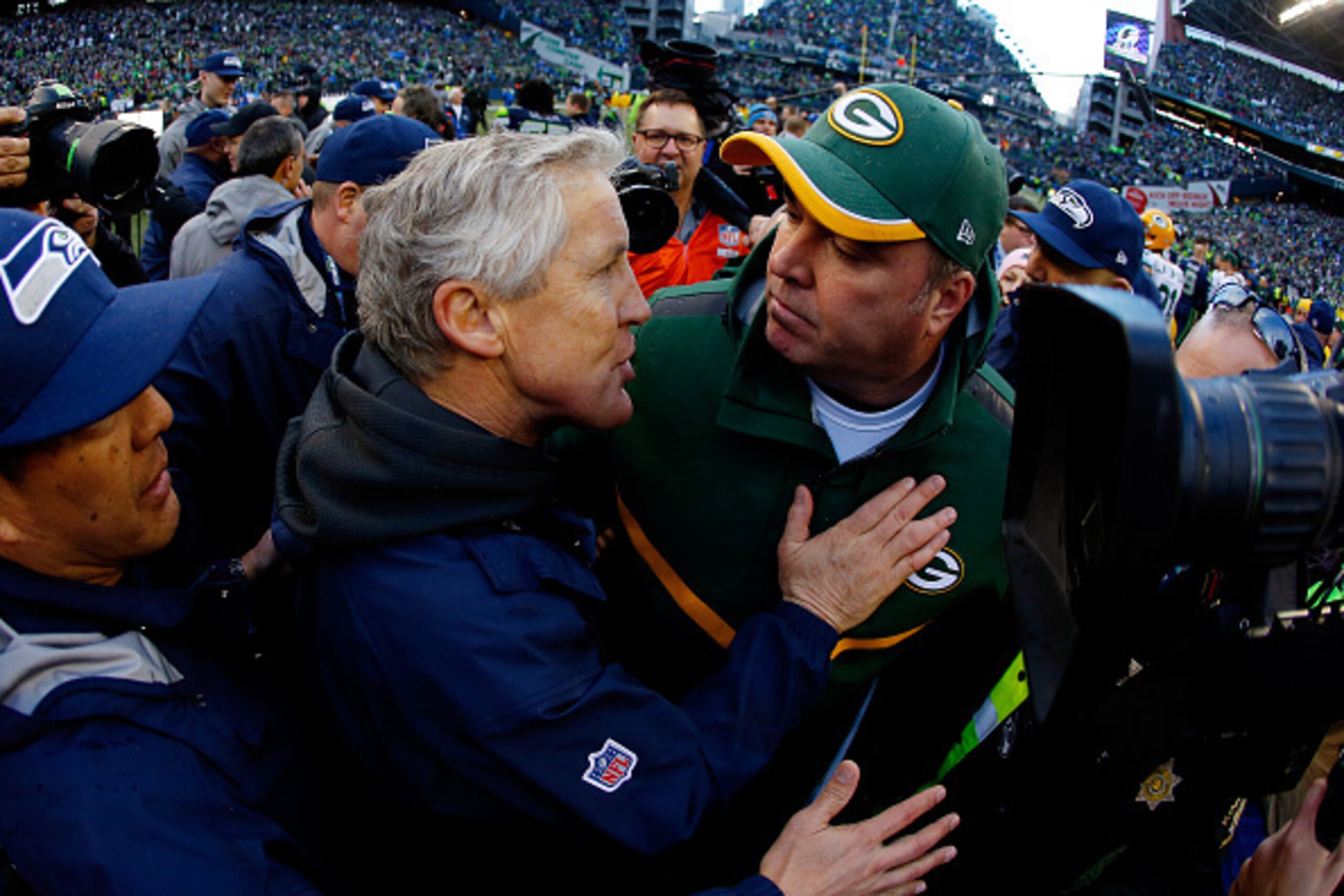 SEATTLE, WA - JANUARY 18: Head coach Pete Carroll of the Seattle Seahawks greets head coach Mike McCarthy of the Green Bay Packers after the Seahawks won the 2015 NFC Championship game at CenturyLink Field on January 18, 2015 in Seattle, Washington.  (Pho