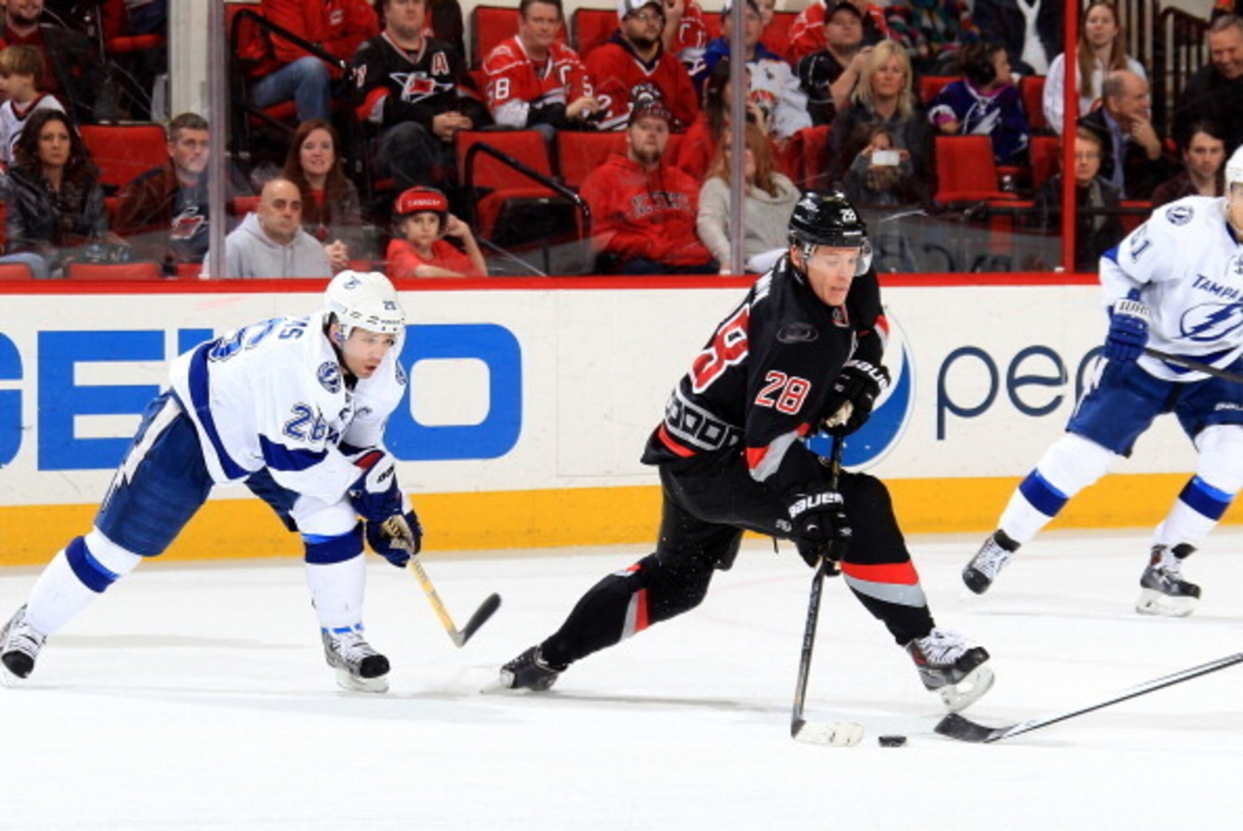 RALEIGH, NC - JANUARY 19: Alexander Semin #28 of the Carolina Hurricanes is hooked late in the game by Martin St. Louis #26 of the Tampa Bay Lightning during their NHL game at PNC Arena on January 19, 2014 in Raleigh, North Carolina.  (Photo by Gregg Forw
