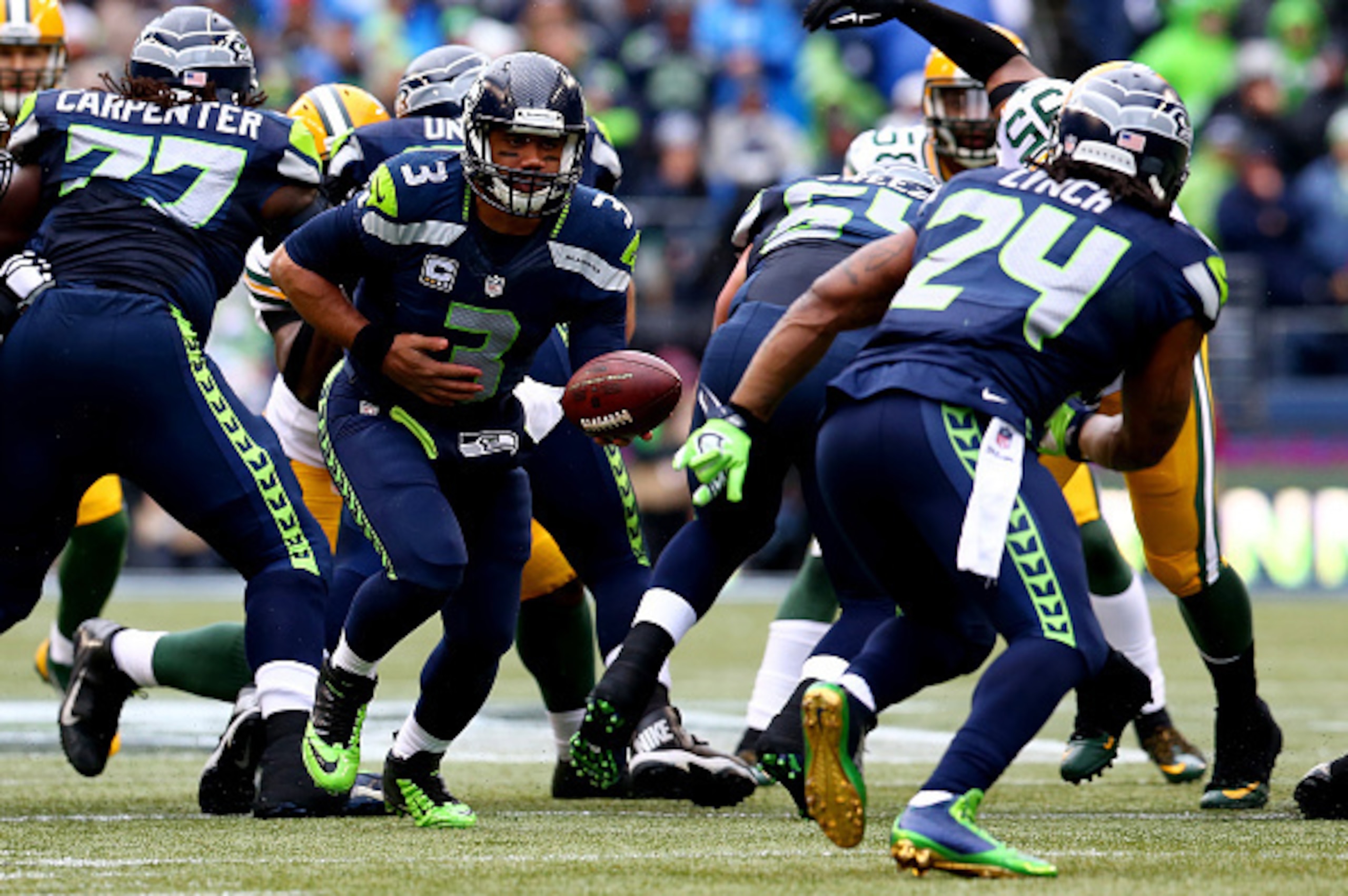 SEATTLE, WA - JANUARY 18:  Russell Wilson #3 drops back to hand the ball off to Marshawn Lynch #24 of the Seattle Seahawks against the Green Bay Packers during the 2015 NFC Championship game at CenturyLink Field on January 18, 2015 in Seattle, Washington.