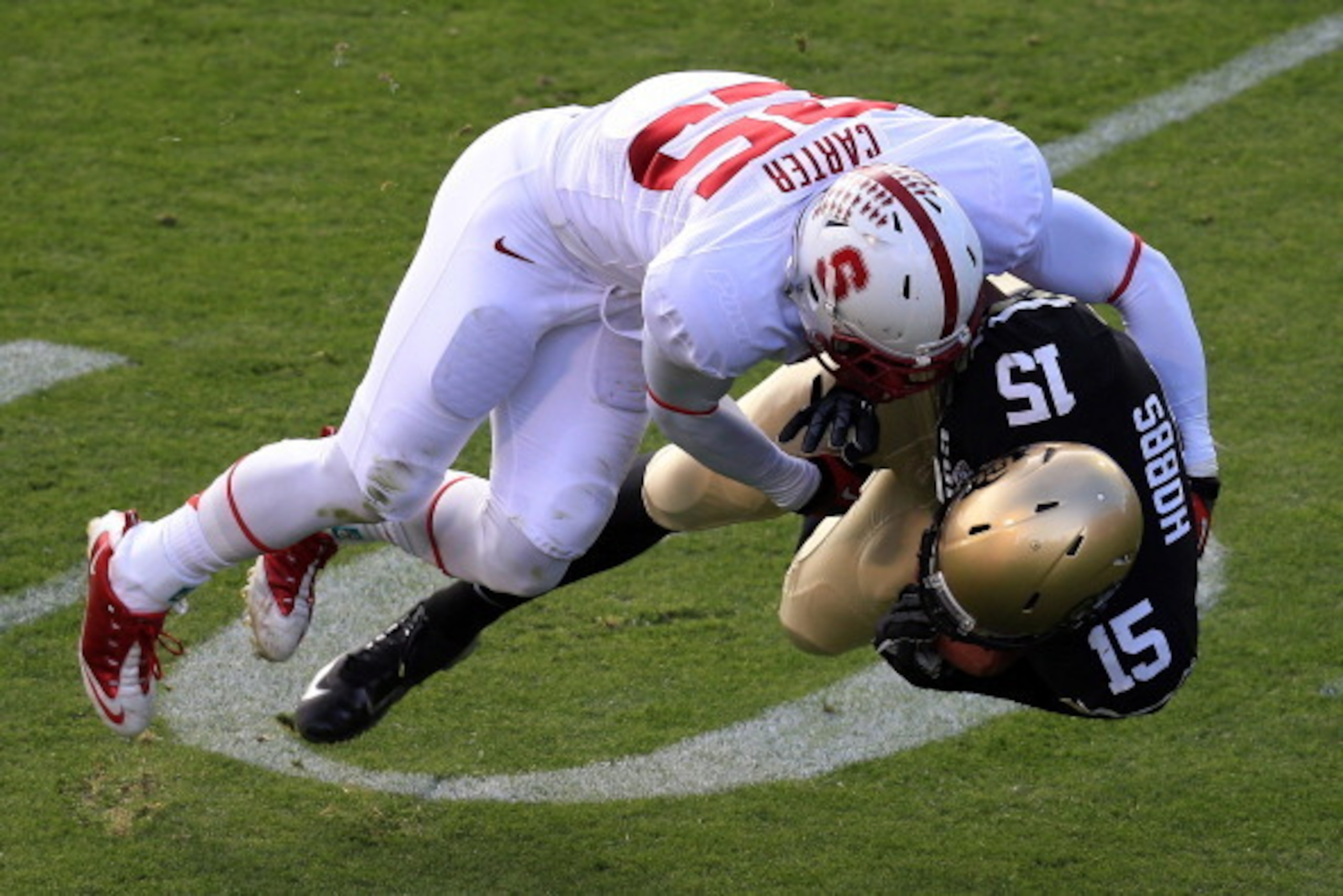BOULDER, CO - NOVEMBER 03:  Tight end Vincent Hobbs #15 of the Colorado Buffaloes makes a reception and is tackled by cornerback Alex Carter #25 of the Stanford Cardinal at Folsom Field on November 3, 2012 in Boulder, Colorado. The Cardinal defeated the B