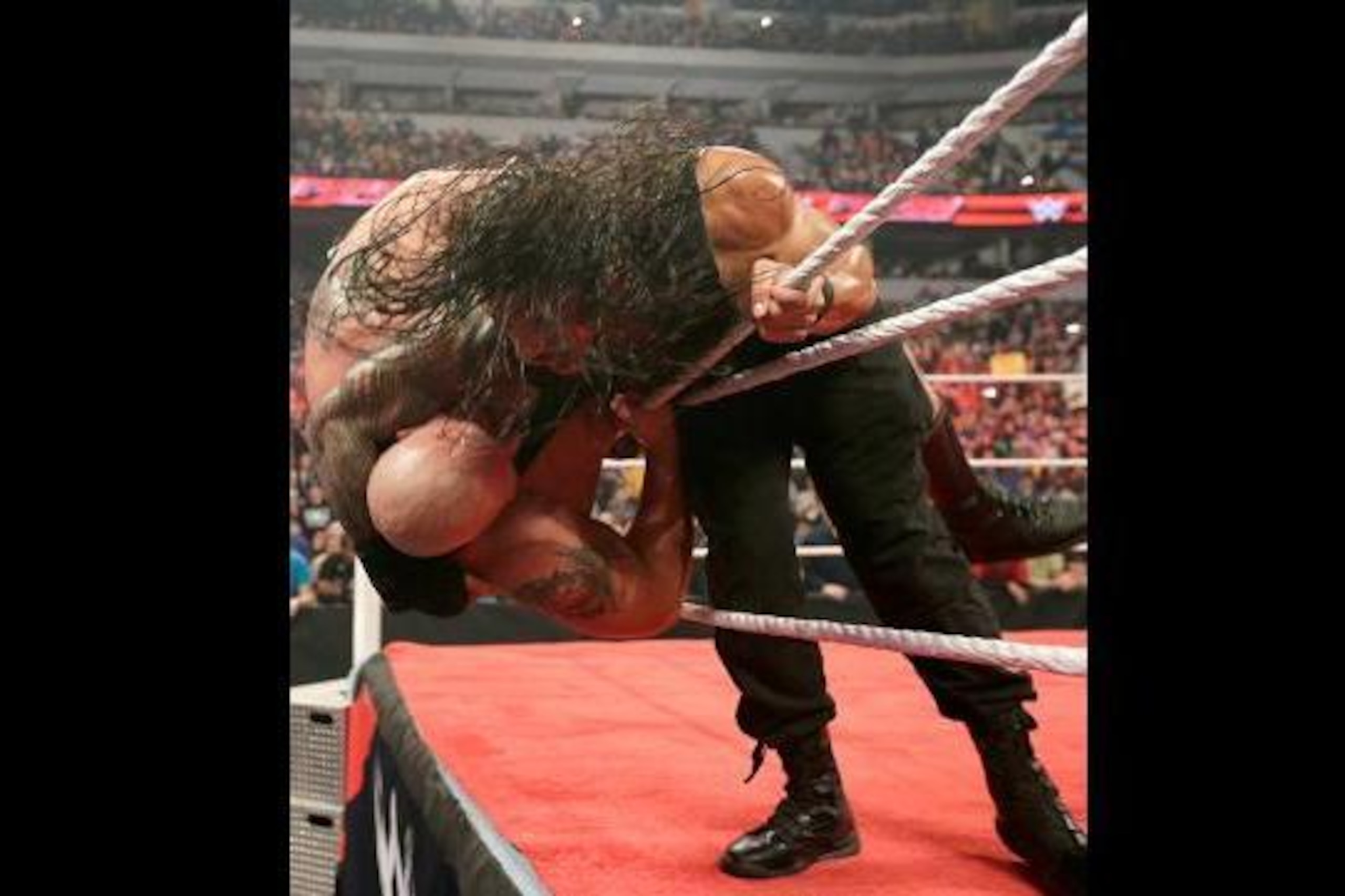 Roman Reigns sends Big Show over the top rope.