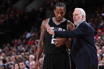 PORTLAND, OR - DECEMBER 15:  Kawhi Leonard #2 and Gregg Popovich of the San Antonio Spurs talk against the Portland Trail Blazers on December 15, 2014 at the Moda Center Arena in Portland, Oregon. NOTE TO USER: User expressly acknowledges and agrees that,