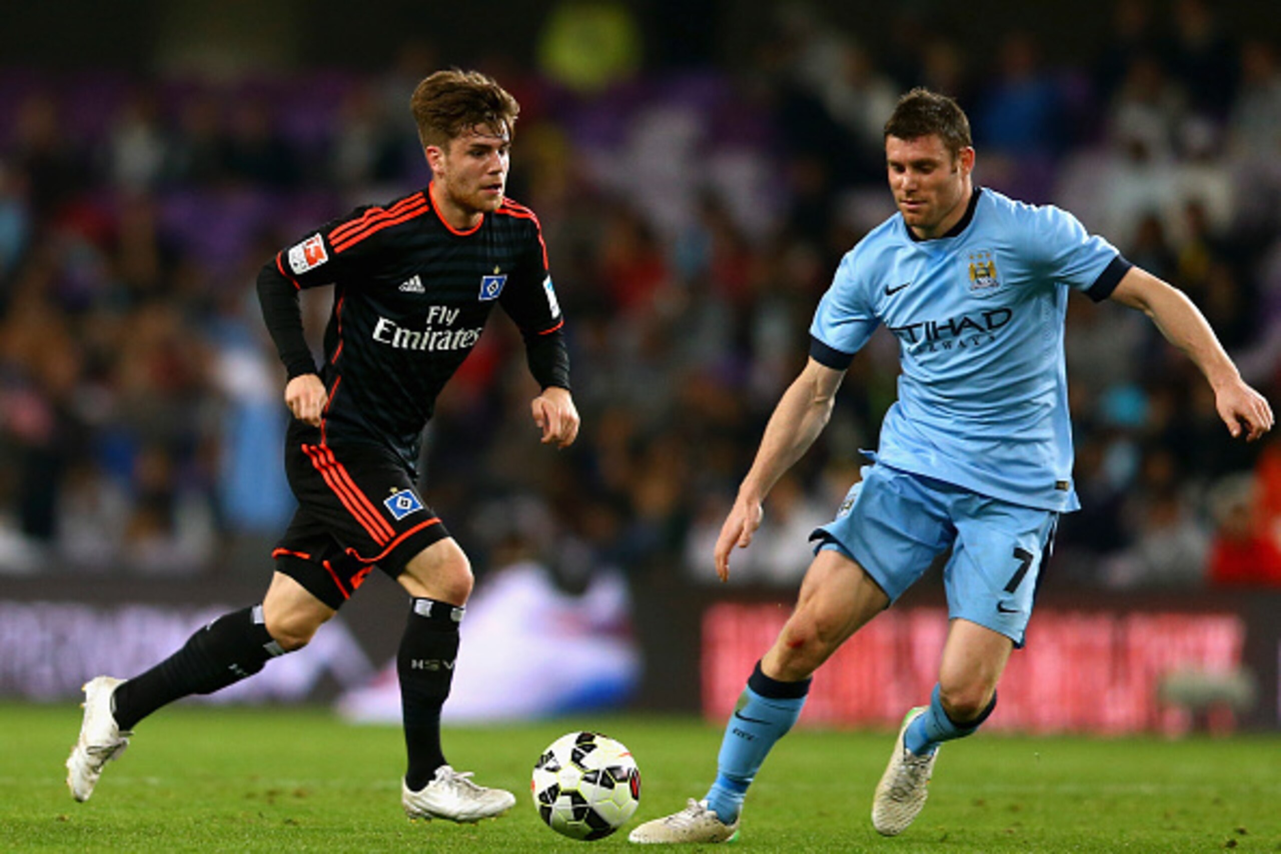 AL AIN, UNITED ARAB EMIRATES - JANUARY 21: Phillip Muller of Hamburg controls the ball against James Milner of Manchester City during the friendly match between Hamburg SV and Manchester City at Hazza bin Zayed Stadium on January 21, 2015 in Al Ain, Unite