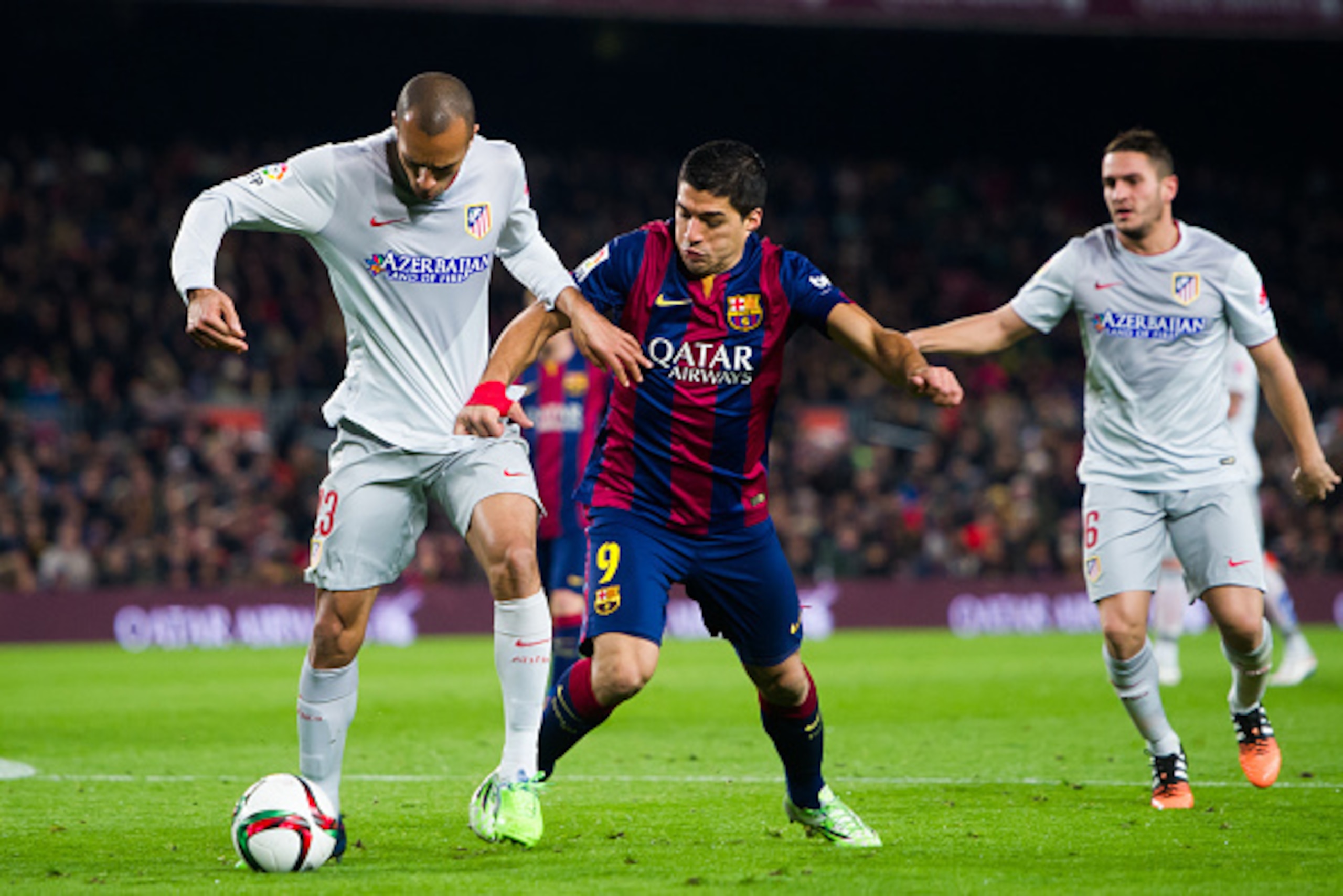BARCELONA, SPAIN - JANUARY 21:  Joao Miranda (L) of Club Atletico de Madrid and Luis Suarez of FC Barcelona fight for the ball during the Copa del Rey Quarter-Final First Leg match between FC Barcelona and Club Atletico de Madrid at Camp Nou on January 21