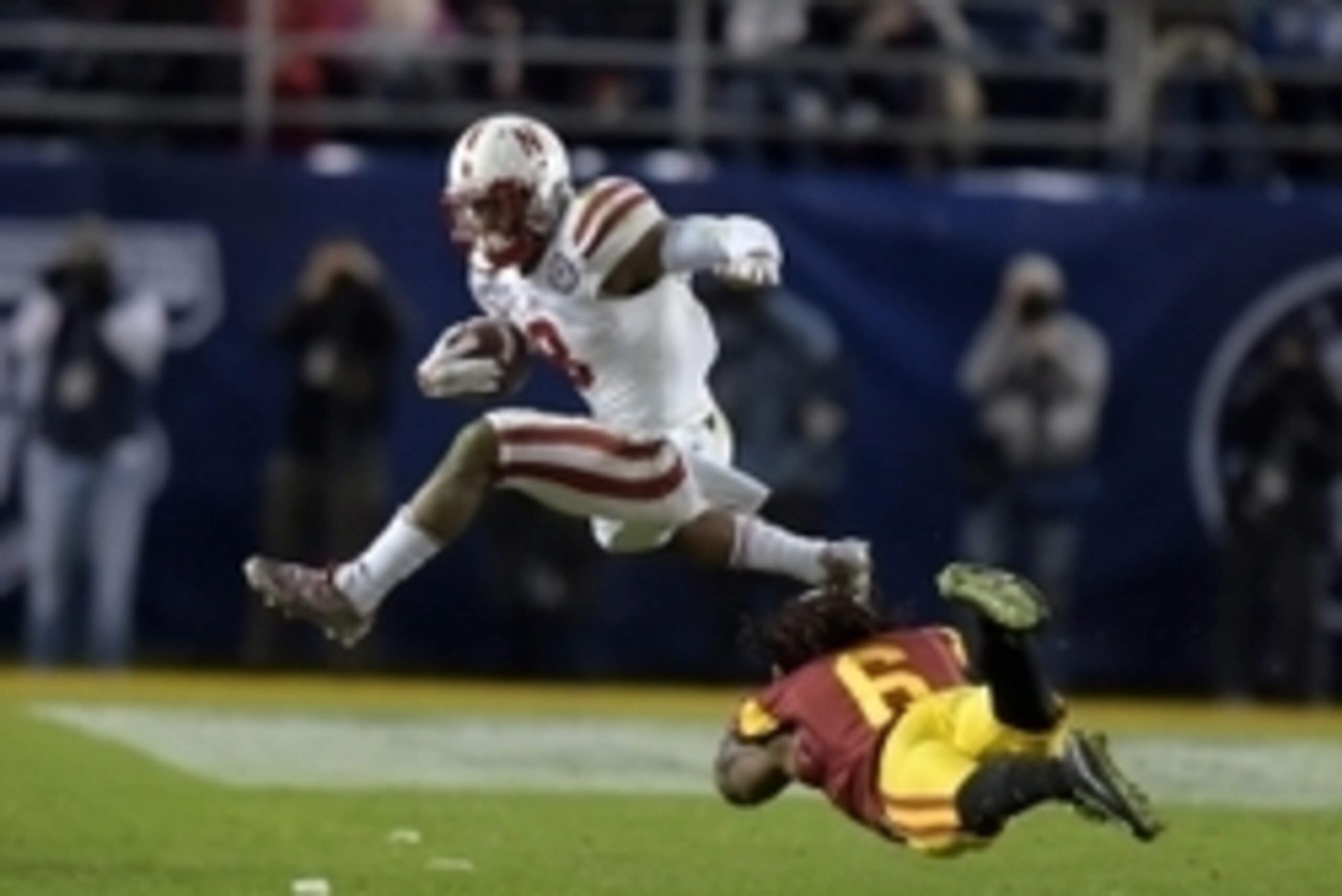 Dec 27, 2014; San Diego, CA, USA; Nebraska Cornhuskers player Ameer Abdullah (8) jumps over Southern California Trojans cornerback Josh Shaw (6) in the fourth quarter in the 2014 Holiday Bowl at Qualcomm Stadium.  USC won 45-42.  Mandatory Credit: Kirby L