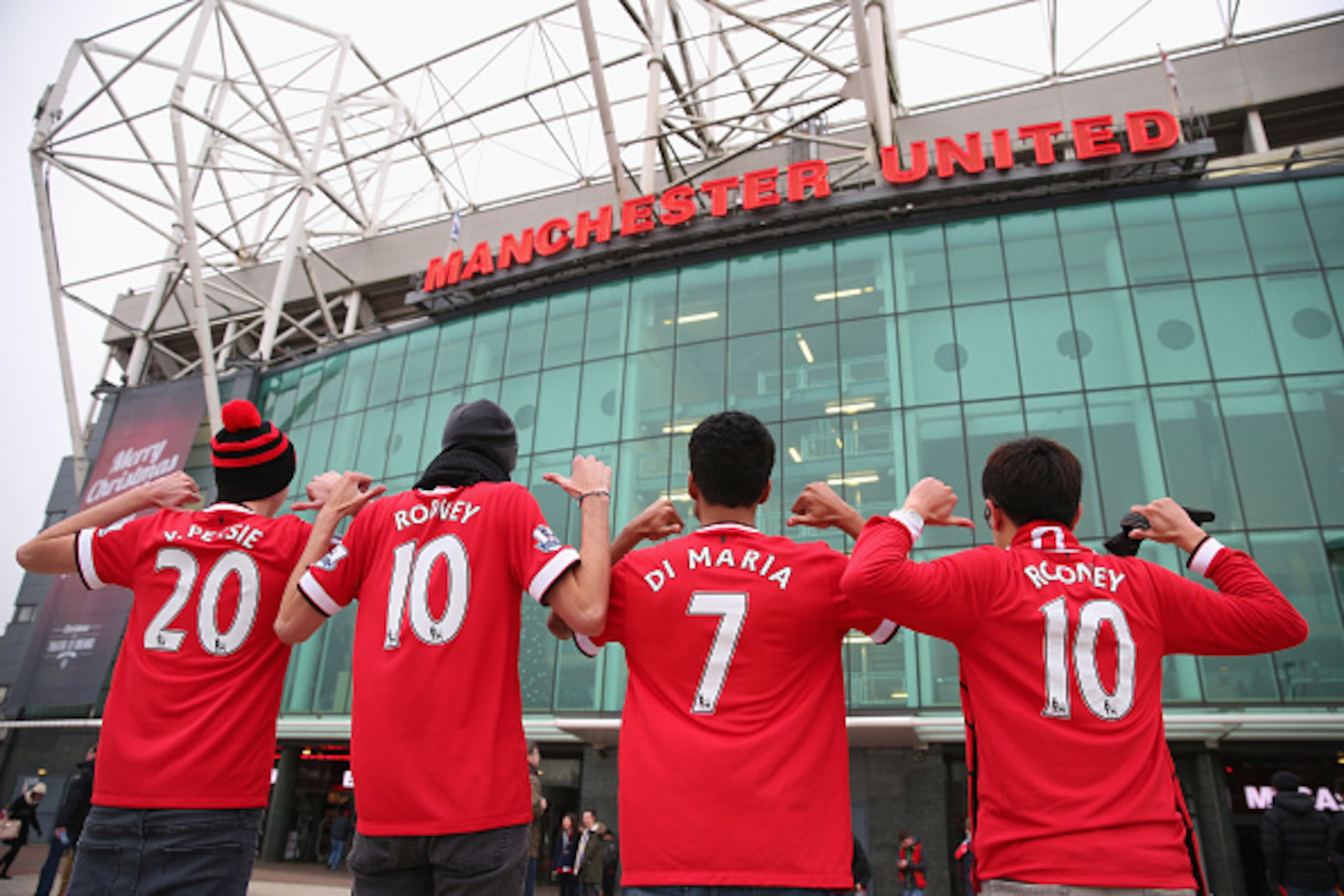 MANCHESTER, ENGLAND - DECEMBER 26:  Manchester United fans pose for a photograph outside Old Trafford prior to the Barclays Premier League match between Manchester United and Newcastle United at Old Trafford on December 26, 2014 in Manchester, England.  (
