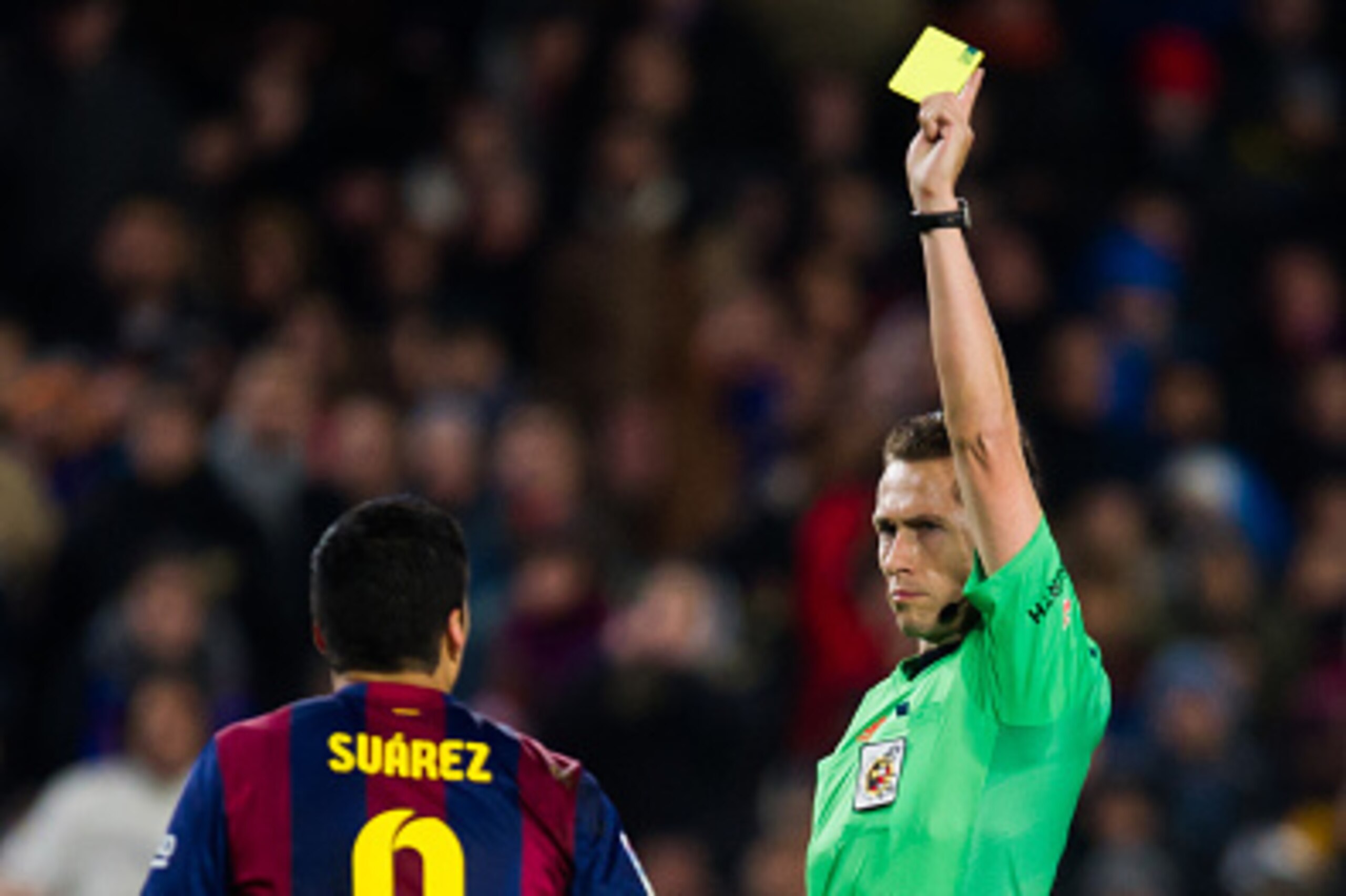 BARCELONA, SPAIN - JANUARY 21:  Luis Suarez of FC Barcelona is shown a yellow card by referee Jose Luis Gonzalez during the Copa del Rey Quarter-Final First Leg match between FC Barcelona and Club Atletico de Madrid at Camp Nou on January 21, 2015 in Barc