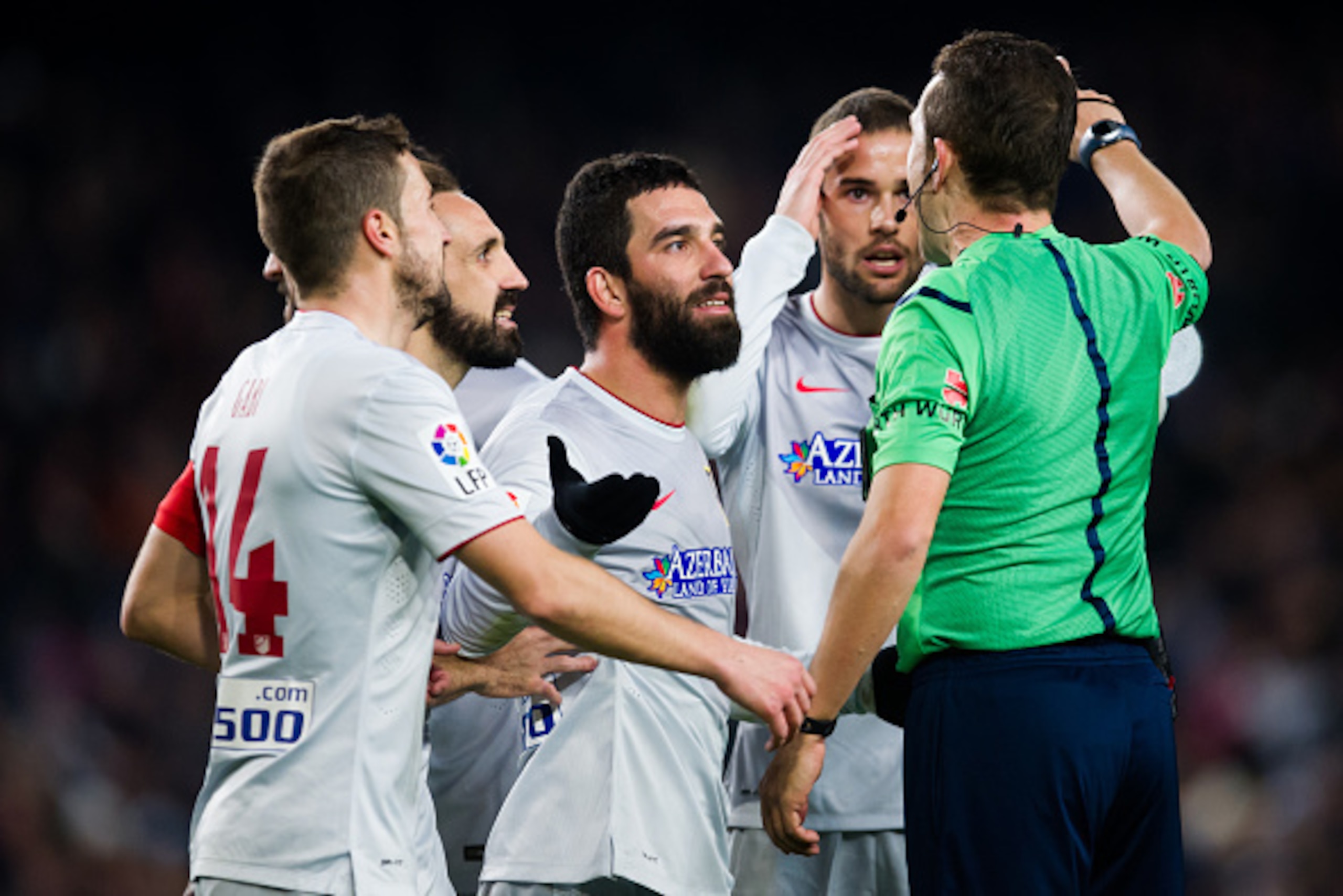 BARCELONA, SPAIN - JANUARY 21:  (L-R) Gabriel 'Gabi' Fernandez, Juan Francisco 'Juanfran' Torres, Arda Turan and Mario Suarez of Club Atletico de Madrid argue with referee Jose Luis Gonzalez during the Copa del Rey Quarter-Final First Leg match between FC