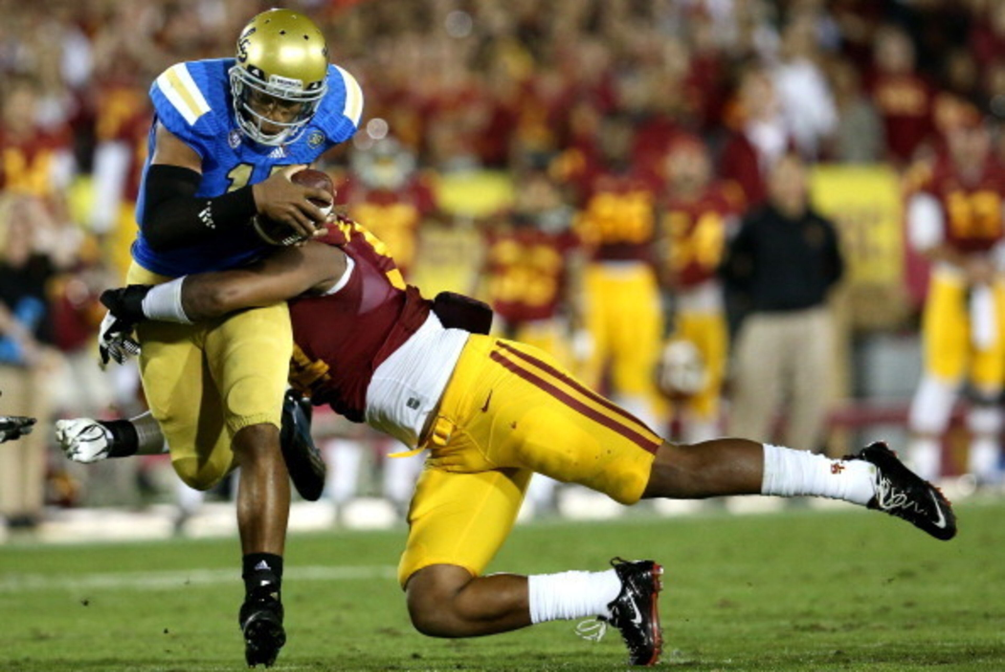 LOS ANGELES, CA - NOVEMBER 30:  Quarterback Brett Hundley #17 of the UCLA Bruins carries the ball as he is tackled by defensive end Leonard Williams #94 of the USC Trojans at Los Angeles Coliseum on November 30, 2013 in Los Angeles, California.  (Photo by