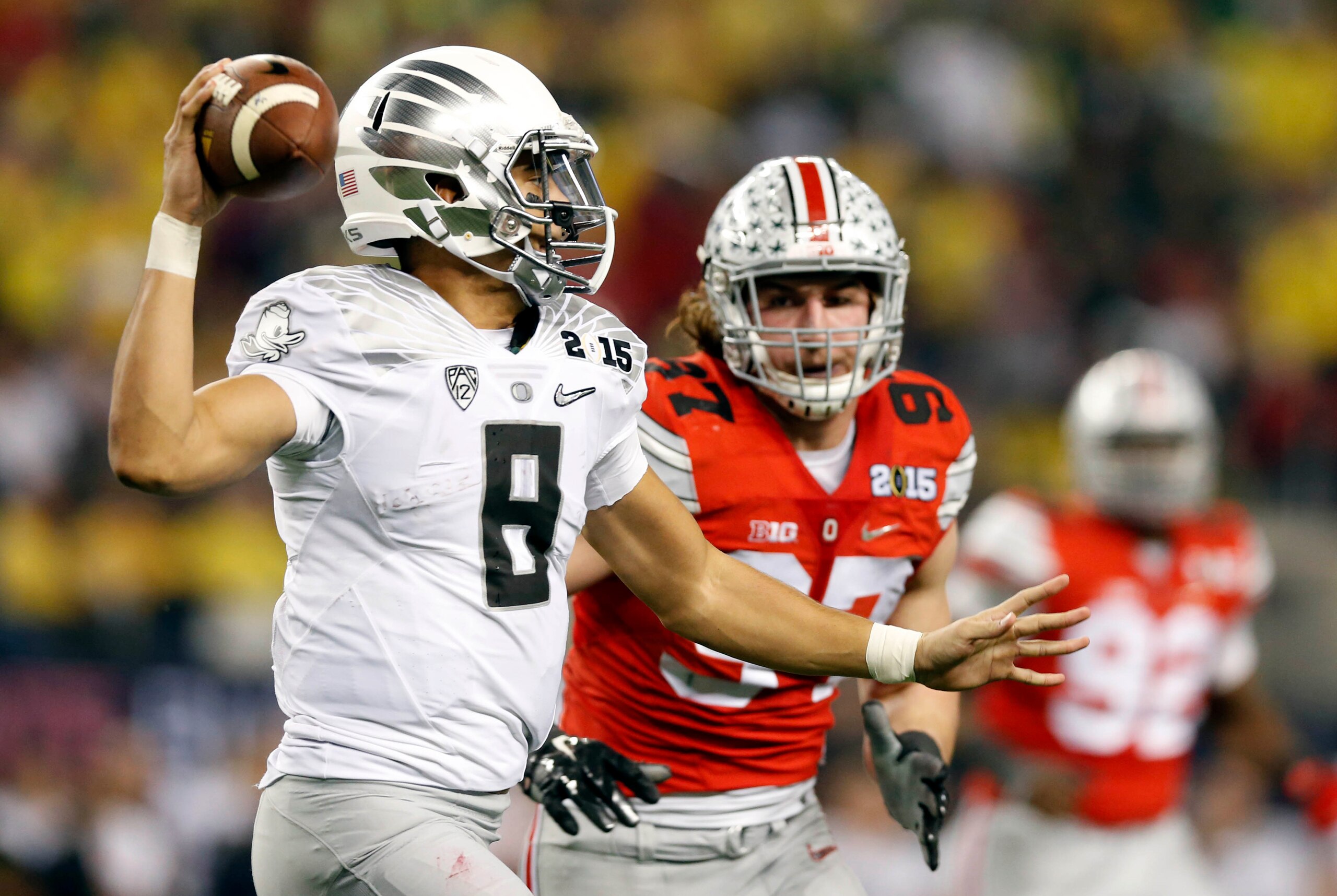 Jan 12, 2015; Arlington, TX, USA; Oregon Ducks quarterback Marcus Mariota (8) is pressured by Ohio State Buckeyes defensive lineman Joey Bosa (97) in the second half in the 2015 CFP National Championship Game at AT&T Stadium. Mandatory Credit: Matthew Emm