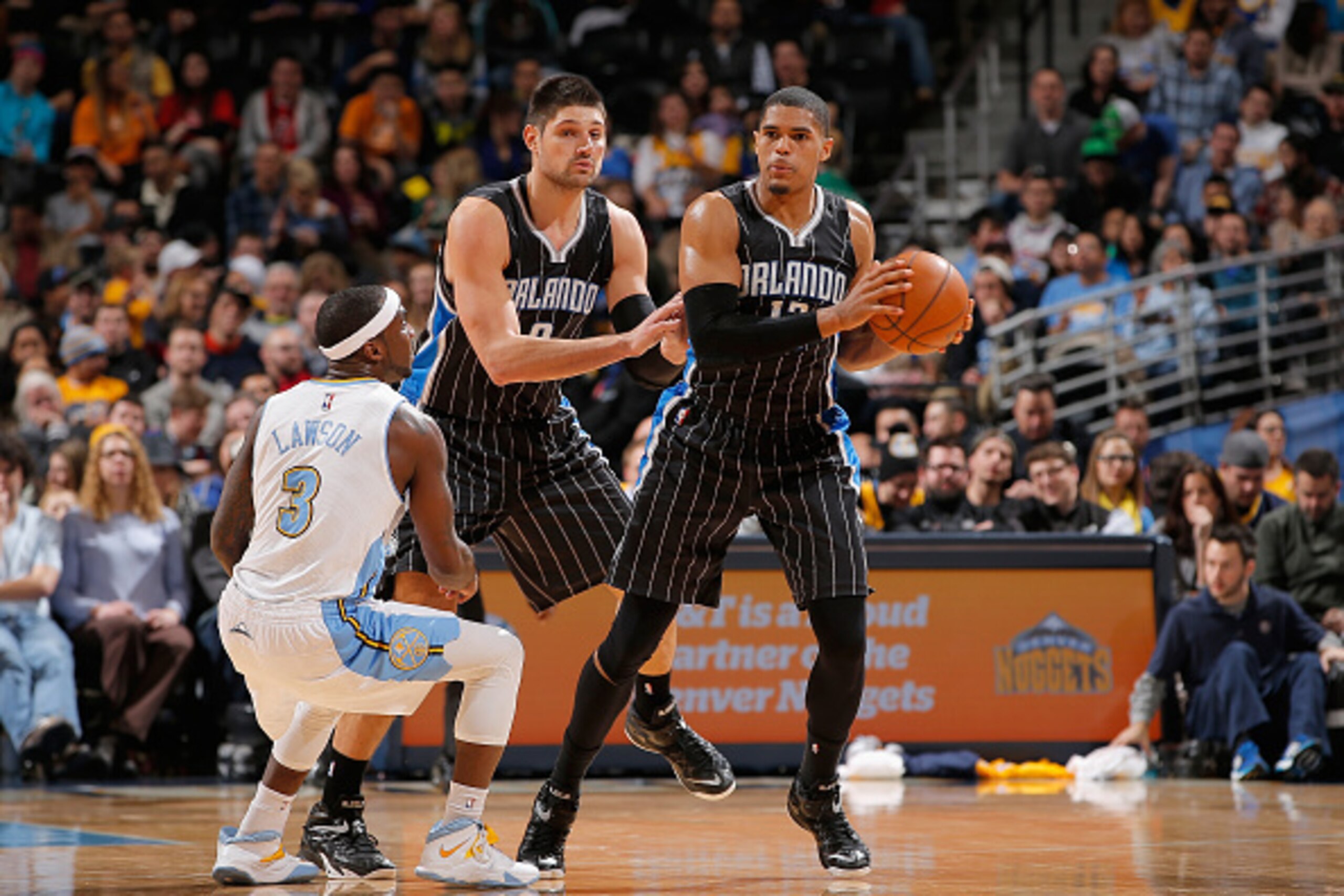 DENVER, CO - JANUARY 07:  Tobias Harris #12 of the Orlando Magic controls the ball as Ty Lawson #3 of the Denver Nuggets and Nikola Vucevic #9 of the Orlando Magic follow the play at Pepsi Center on January 7, 2015 in Denver, Colorado. The Nuggets defeate