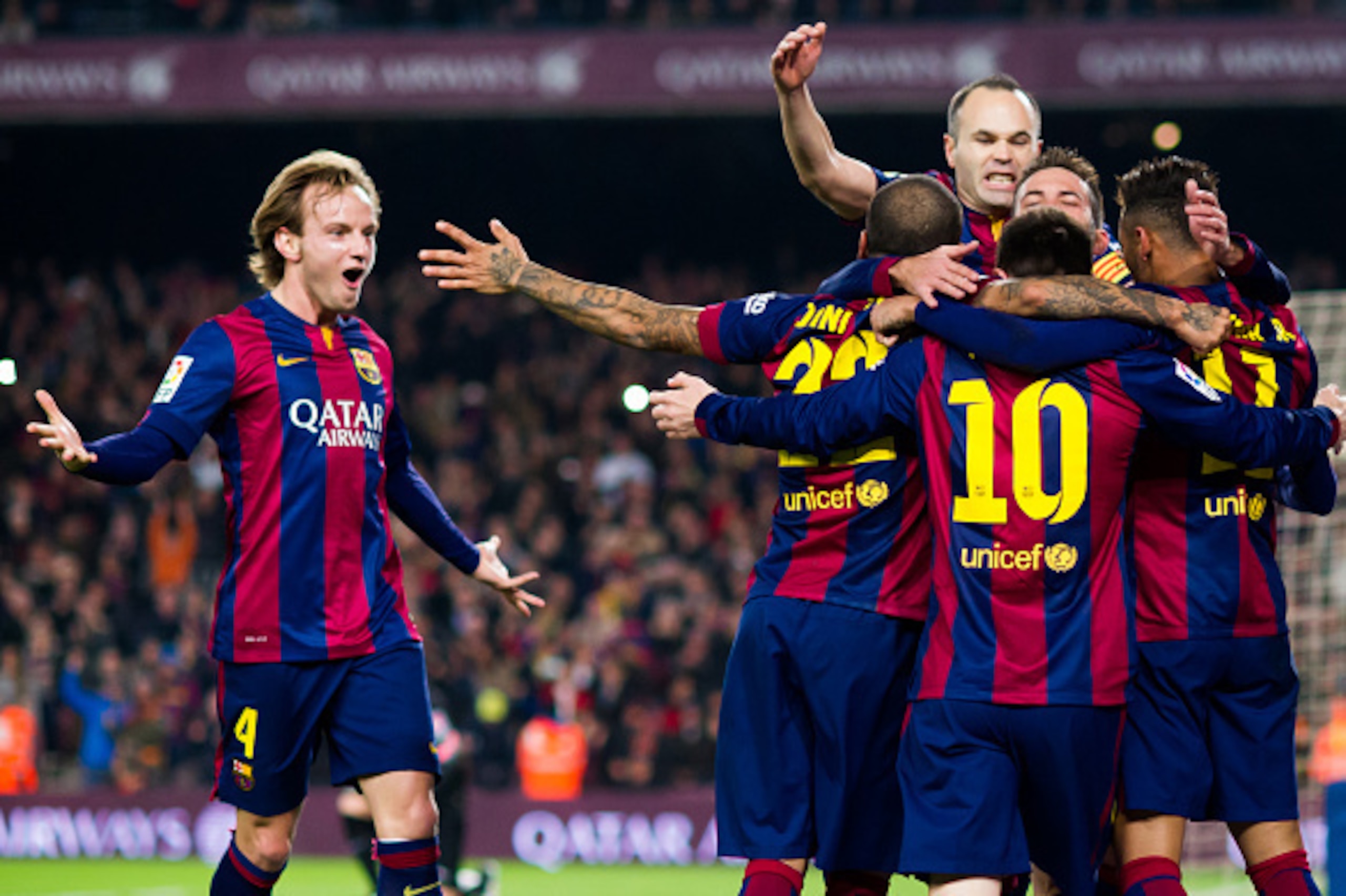 BARCELONA, SPAIN - JANUARY 11: Ivan Rakitic (L) and Andres Iniesta (top) of FC Barcelona celebrate with their team-mates after Neymar Santos Jr scored the opening goal during the La Liga match between FC Barcelona and Club Atletico de Madrid at Camp Nou o