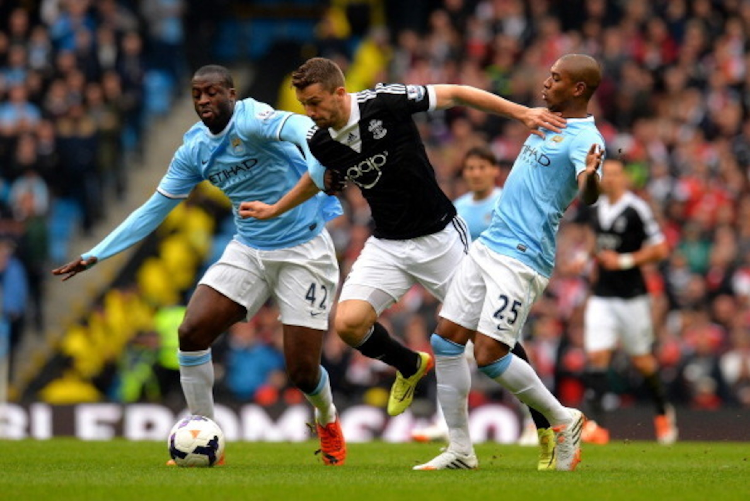 MANCHESTER, ENGLAND - APRIL 05:  Jay Rodriguez of Southampton is challenged by Yaya Toure (L) and Fernandinho (R) of Manchester City during the Barclays Premier League match between Manchester City and Southampton at Etihad Stadium on April 5, 2014 in Man