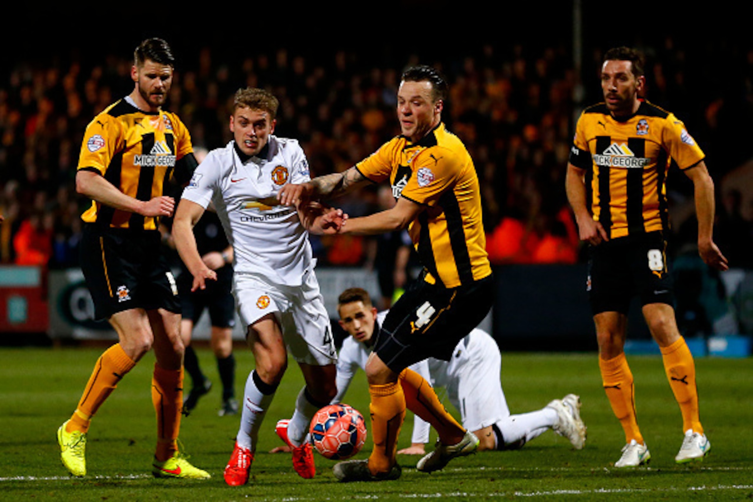 CAMBRIDGE, ENGLAND - JANUARY 23: James Wilson of Manchester United battles for the ball with Josh Coulson of Cambridge United during the FA Cup Fourth Round match between Cambridge United and Manchester United at The R Costings Abbey Stadium on January 2 CAMBRIDGE, ENGLAND - JANUARY 23: James Wilson of Manchester United battles for the ball with Josh Coulson of Cambridge United during the FA Cup Fourth Round match between Cambridge United and Manchester United at The R Costings Abbey Stadium on January 2