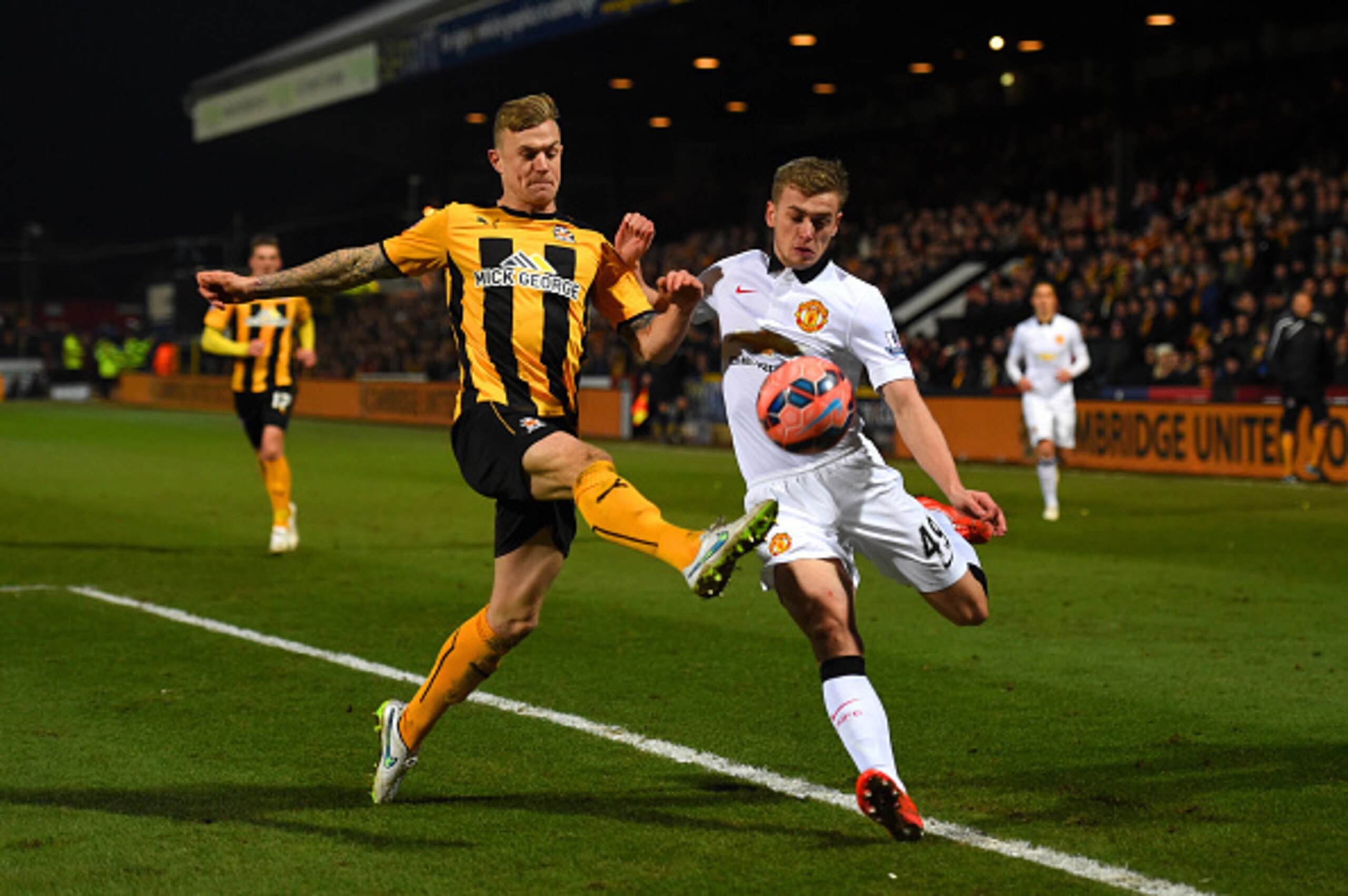 CAMBRIDGE, ENGLAND - JANUARY 23:  James Wilson of Manchester United battles for the ball with Richard Tait of Cambridge United during the FA Cup Fourth Round match between Cambridge United and Manchester United at The R Costings Abbey Stadium on January 2