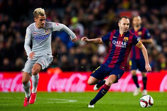 BARCELONA, SPAIN - JANUARY 21:  Andres Iniesta (R) of FC Barcelona conducts the ball close to Antoine Griezmann of Club Atletico de Madrid during the Copa del Rey Quarter-Final First Leg match between FC Barcelona and Club Atletico de Madrid at Camp Nou o