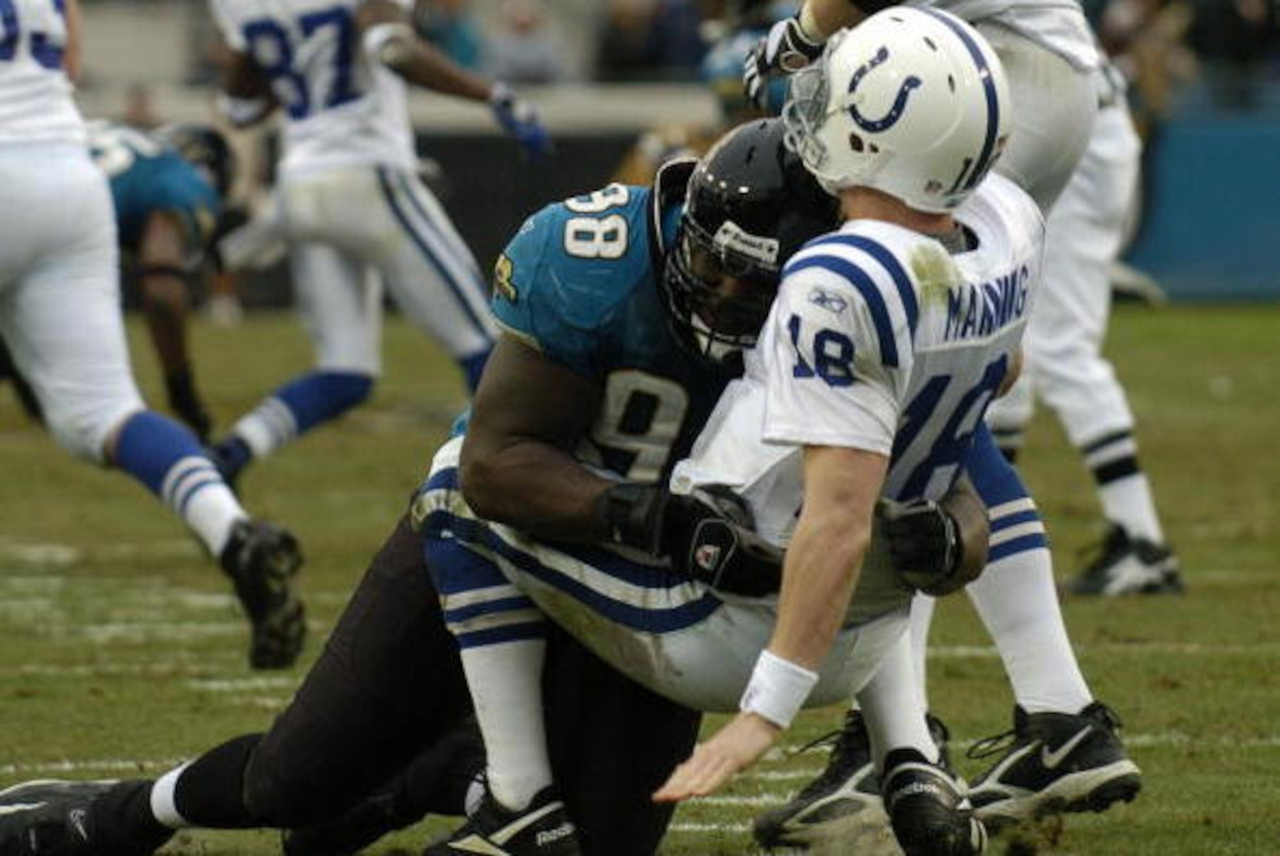 Indianapolis Colts quarterback Peyton Manning tumbles under the pass rush of  Jacksonville Jaguars  defensive tackle John Henderson December 11, 2005 in Jacksonville.  The Colts defeated the Jaguars 26 - 18 to remain undefeated.  (Photo by Al Messerschmid