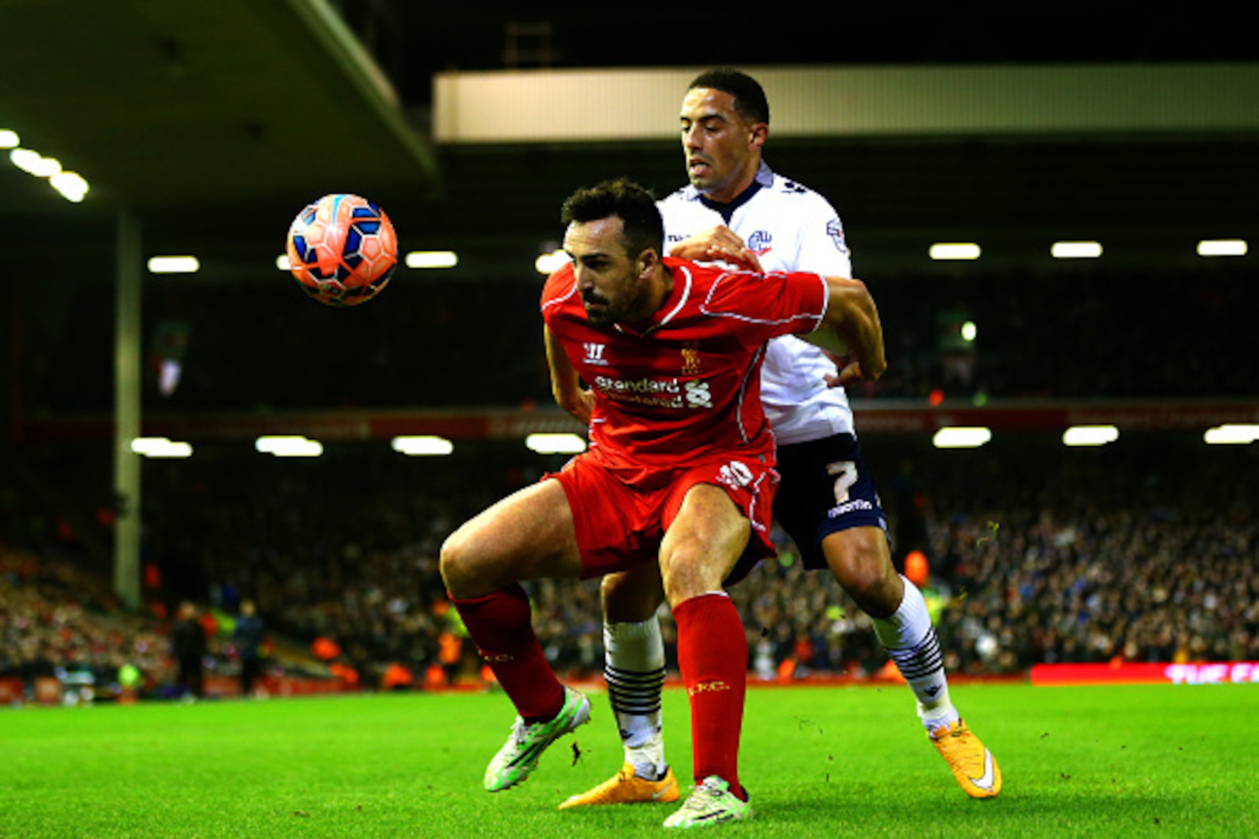 LIVERPOOL, ENGLAND - JANUARY 24:  Jose Enrique of Liverpool shields the ball from Liam Feeney of Bolton Wanderers during the FA Cup Fourth Round match between Liverpool and Bolton Wanderers at Anfield on January 24, 2015 in Liverpool, England.  (Photo by 