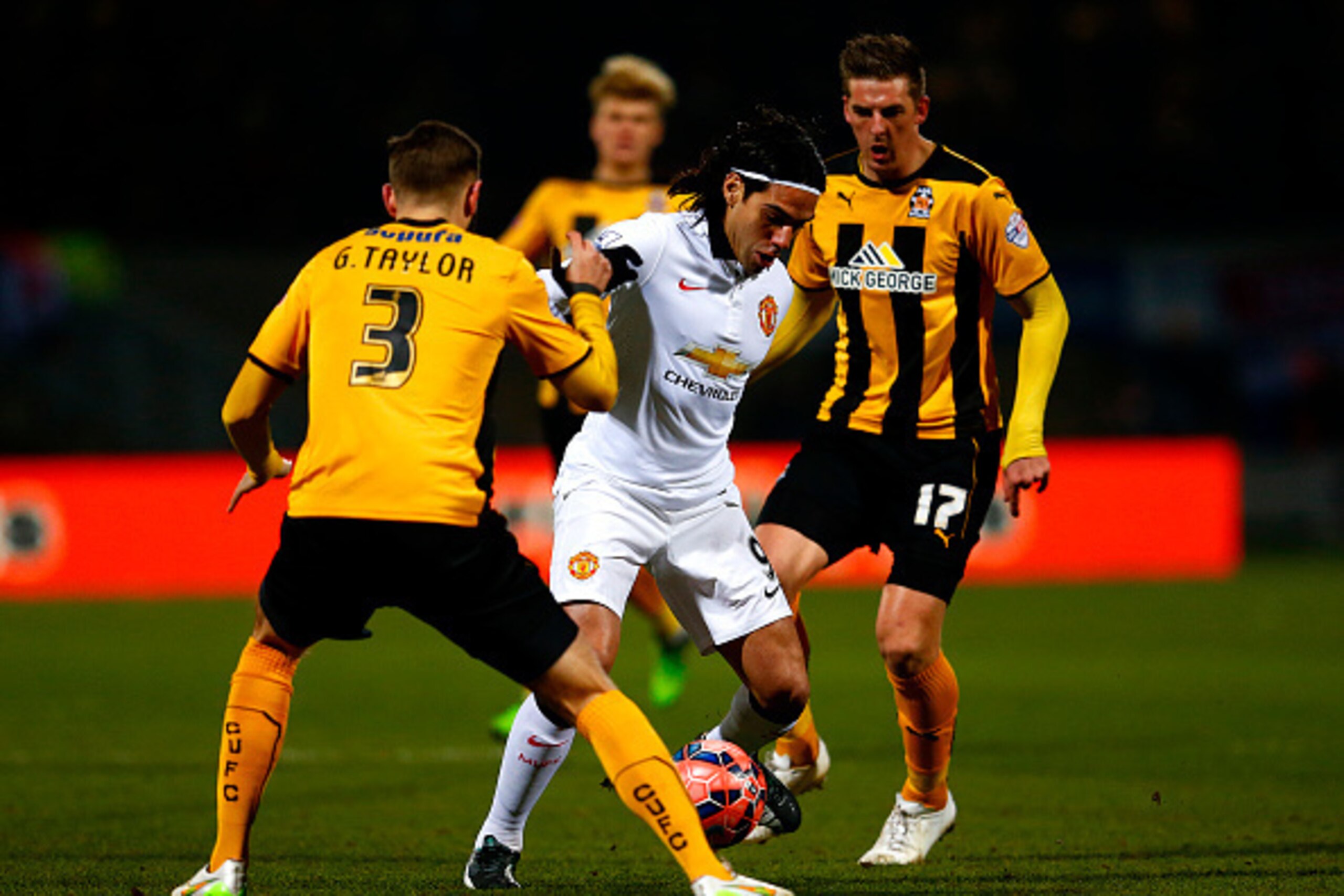 CAMBRIDGE, ENGLAND - JANUARY 23:  Radamel Falcao Garcia of Manchester United battles for the ball with Greg Taylor and Liam Hughes of Cambridge United during the FA Cup Fourth Round match between Cambridge United and Manchester United at The R Costings Ab