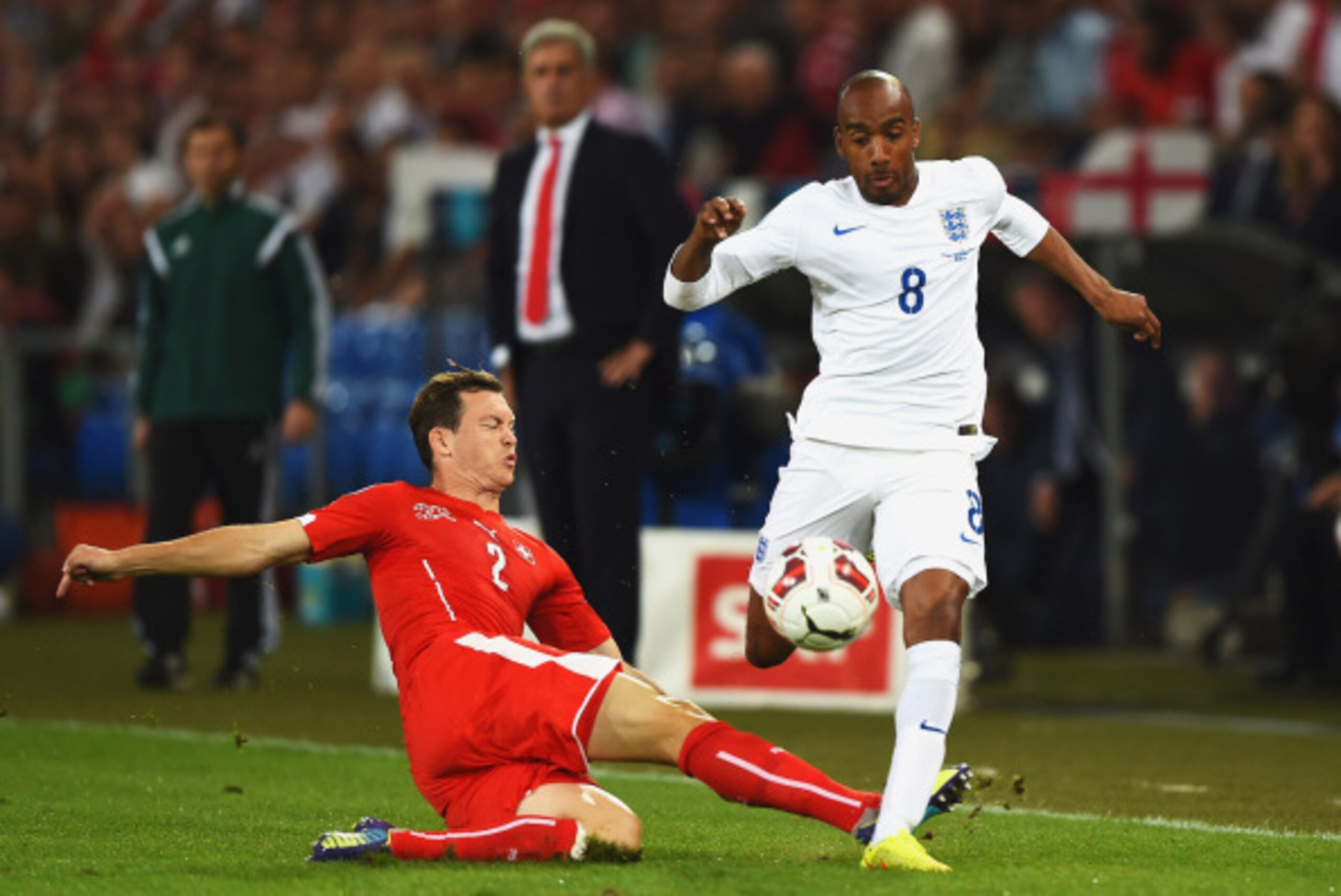 BASEL, SWITZERLAND - SEPTEMBER 08:  Fabian Delph of England is tackled by Stephan Lichtsteiner of Switzerland during the UEFA EURO 2016 Group E qualifying match between Switzerland and England at St Jakob-Park on September 8, 2014 in Basel, Switzerland.  