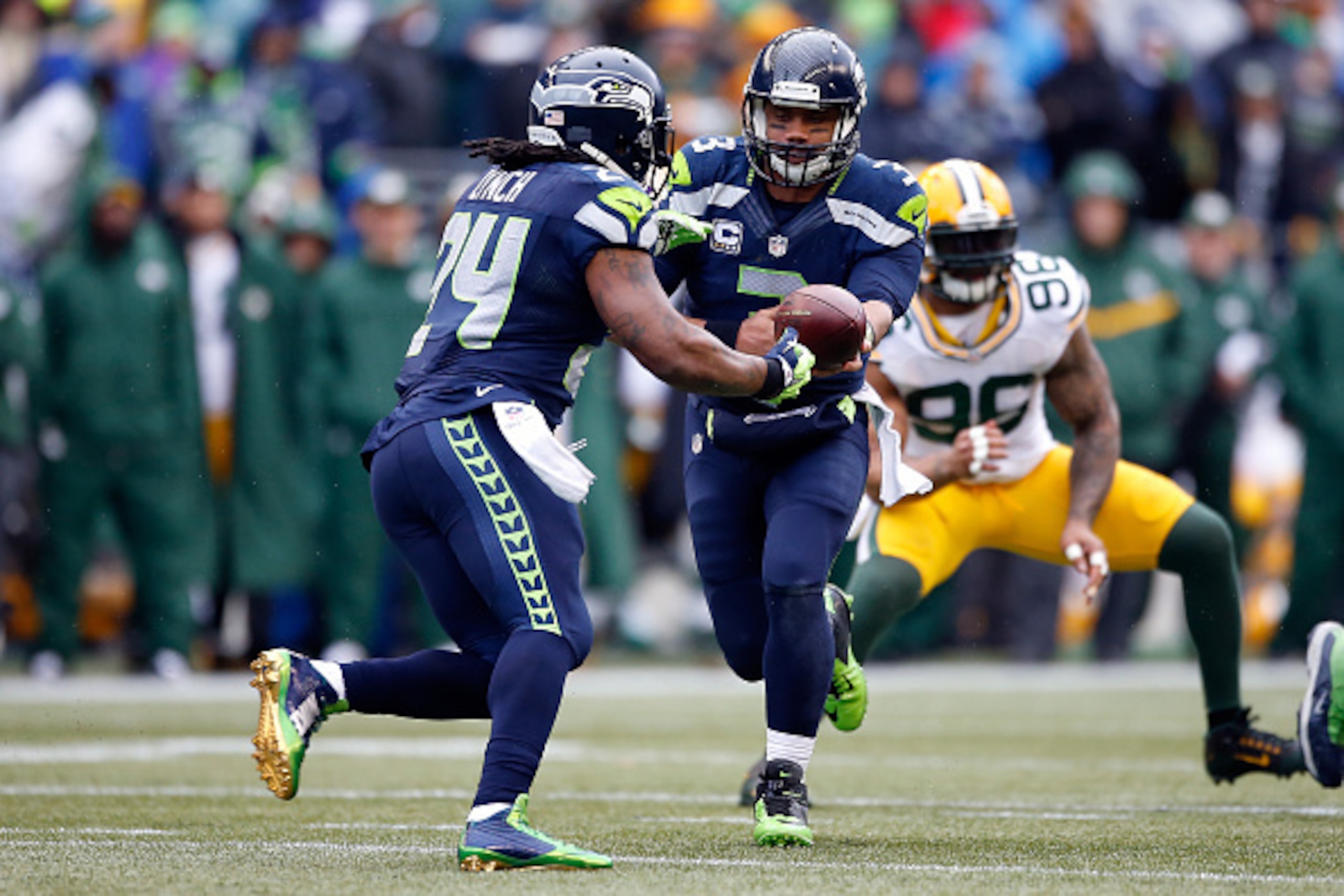 SEATTLE, WA - JANUARY 18:  Russell Wilson #3 hands the ball off to Marshawn Lynch #24 of the Seattle Seahawks against the Green Bay Packers during the 2015 NFC Championship game at CenturyLink Field on January 18, 2015 in Seattle, Washington.  (Photo by O
