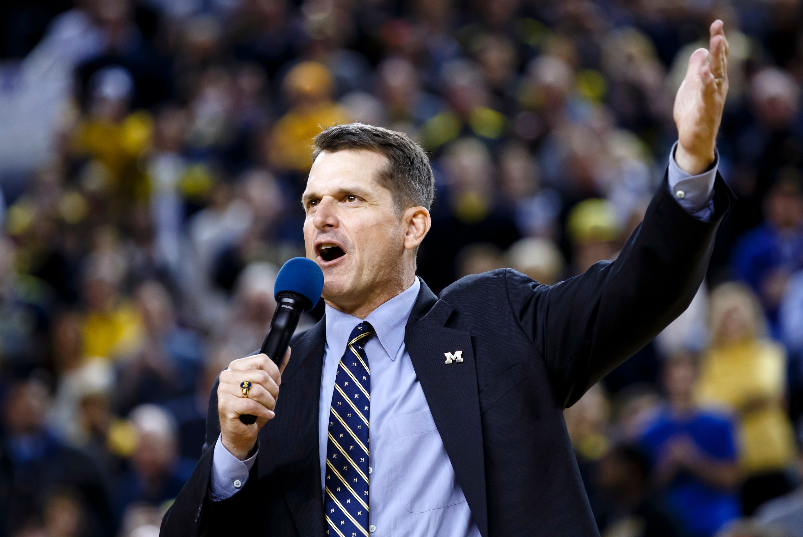 Dec 30, 2014; Ann Arbor, MI, USA; Michigan Wolverines head football coach Jim Harbaugh address the crowd during halftime of the game against the Illinois Fighting Illini at Crisler Center. Mandatory Credit: Rick Osentoski-USA TODAY Sports