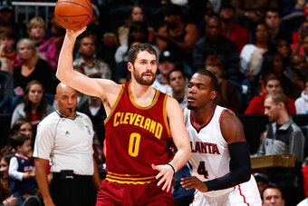 ATLANTA, GA - DECEMBER 30:  Paul Millsap #4 of the Atlanta Hawks defends against Kevin Love #0 of the Cleveland Cavaliers at Philips Arena on December 30, 2014 in Atlanta, Georgia.  NOTE TO USER: User expressly acknowledges and agrees that, by downloading