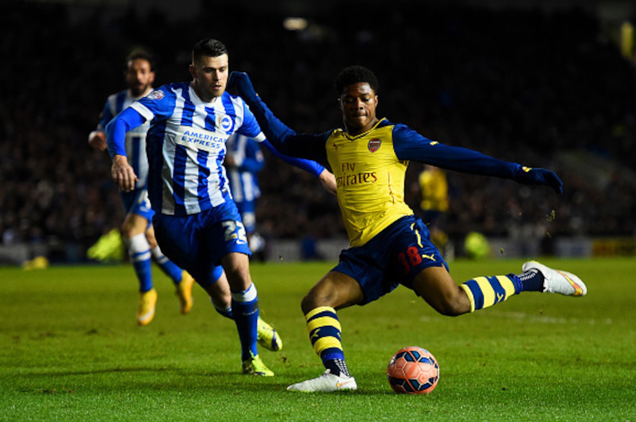 BRIGHTON, ENGLAND - JANUARY 25:  Chuba Akpom of Arsenal crosses the ball under pressure from Danny Holla of Brighton during the FA Cup Fourth Round match between Brighton & Hove Albion and Arsenal at Amex Stadium on January 25, 2015 in Brighton, England. 