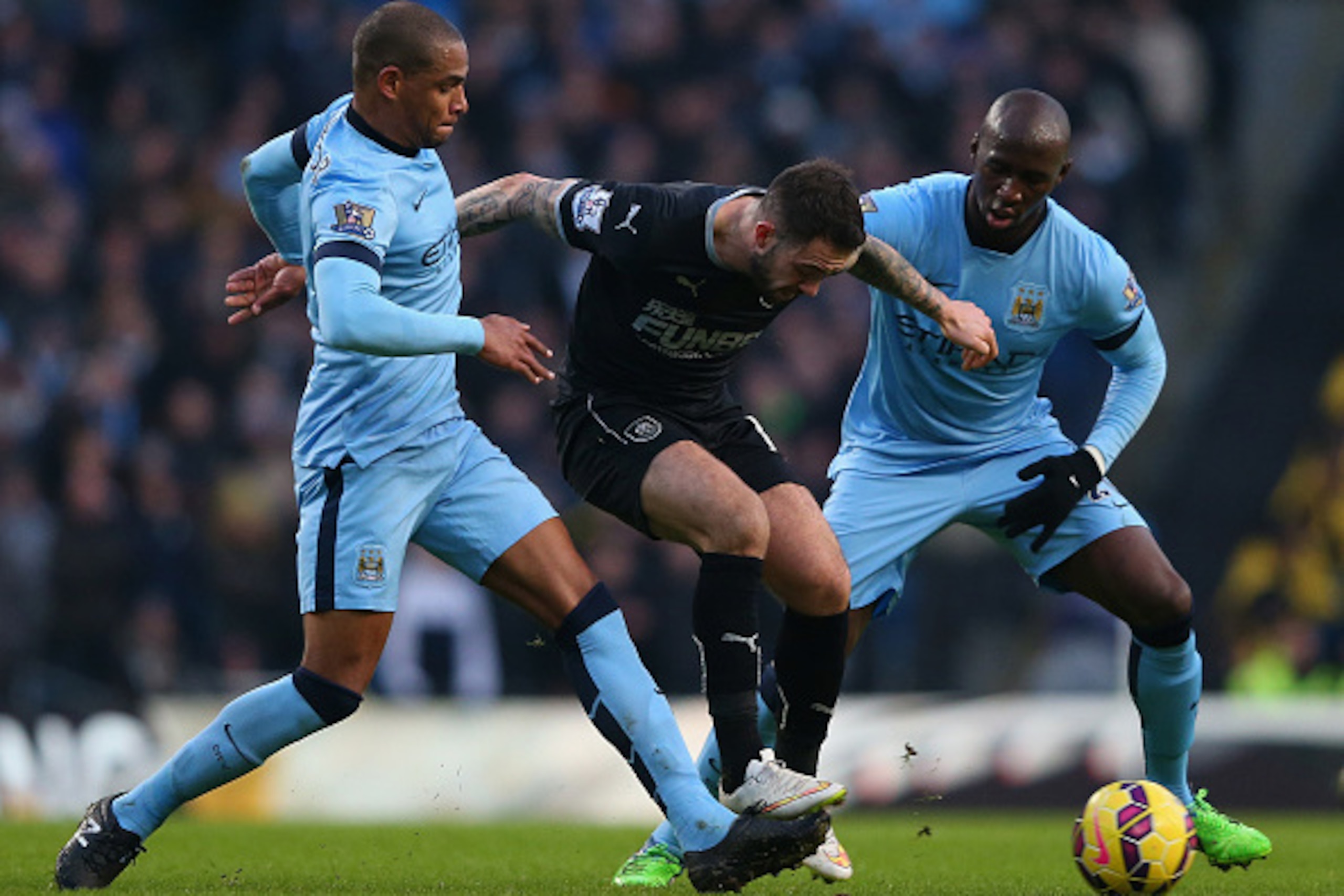 MANCHESTER, ENGLAND - DECEMBER 28:  Danny Ings of Burnley holds off Fernando Reges and Eliaquim Mangala of Manchester City during the Barclays Premier League match between Manchester City and Burnley at Etihad Stadium on December 28, 2014 in Manchester, E