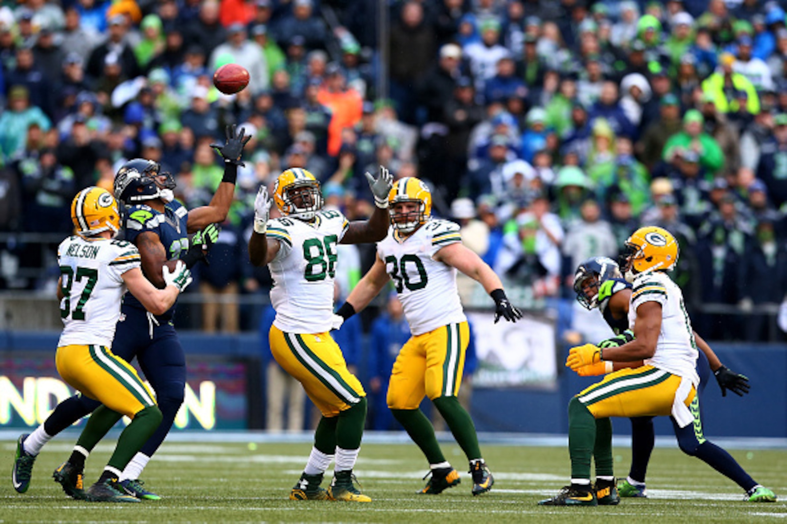 SEATTLE, WA - JANUARY 18: Brandon Bostick #86 of the Green Bay Packers bobbles an onsides kick as Chris Matthews #13 of the Seattle Seahawks and Jordy Nelson #87 of the Green Bay Packers close in during the fourth quarter of the 2015 NFC Championship game