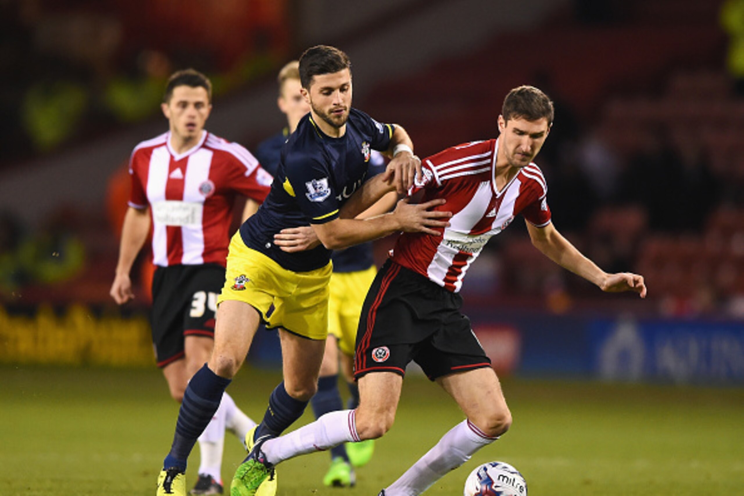 SHEFFIELD, ENGLAND - DECEMBER 16: Shane Long of Southampton challenges Chris Basham of Sheffield United during the Capital One Cup Quarter-Final match between Sheffield United and Southampton at Bramall Lane on December 16, 2014 in Sheffield, England.  (P