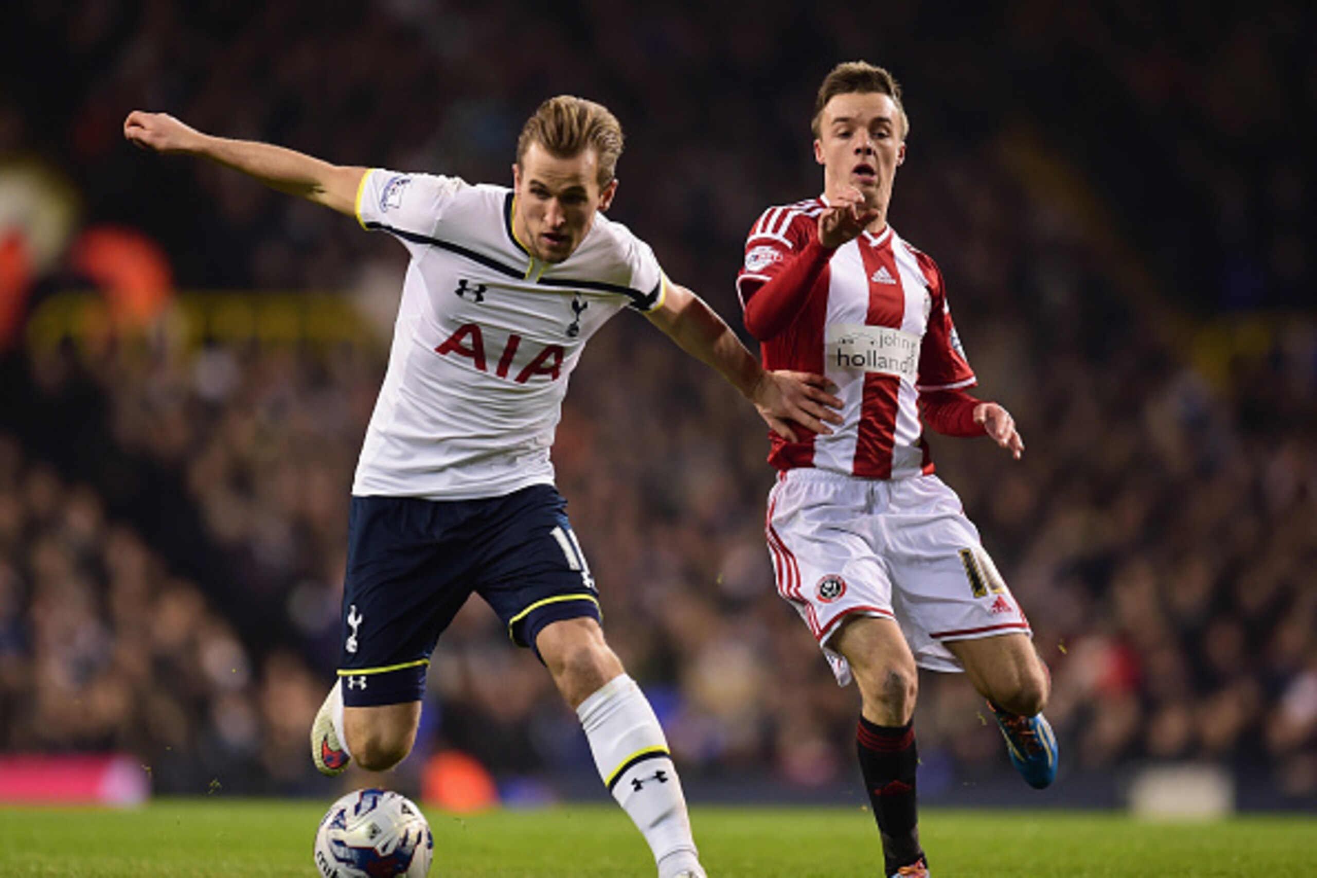 LONDON, ENGLAND - JANUARY 21:  Harry Kane of Spurs holds off Stefan Scougall of Sheffield United during the Capital One Cup Semi-Final first leg match between Tottenham Hotspur and Sheffield United at White Hart Lane on January 21, 2015 in London, England