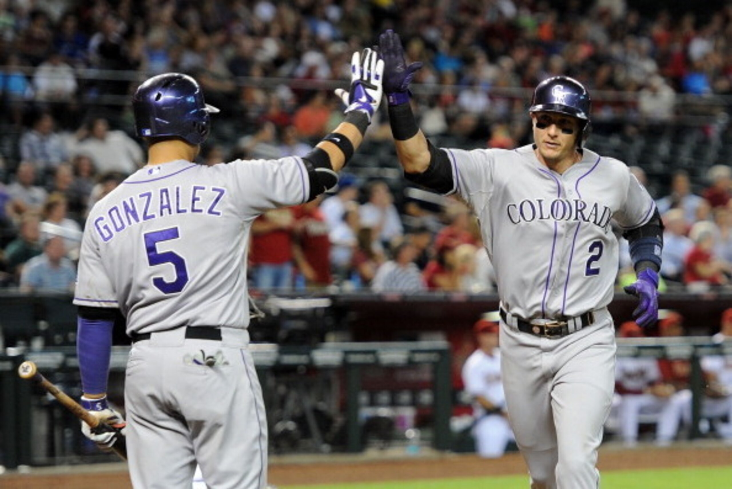 PHOENIX, AZ - APRIL 28:  Troy Tulowitzki #2 of the Colorado Rockies is congratulated by teammate Carlos Gonzalez #5 on his sixth-inning home run against the Arizona Diamondbacks at Chase Field on April 28, 2014 in Phoenix, Arizona.  (Photo by Norm Hall/Ge