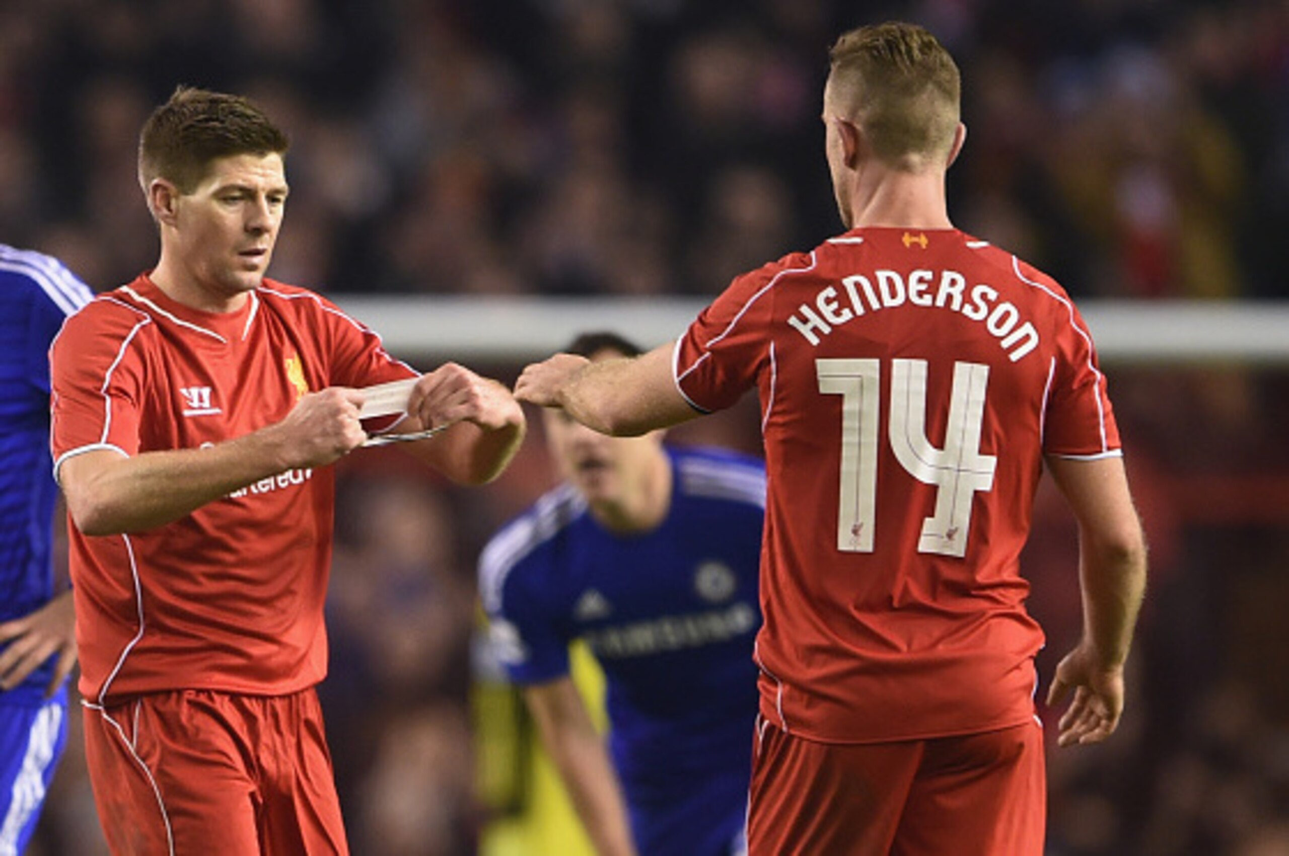 LIVERPOOL, ENGLAND - JANUARY 20:  Steven Gerrard of Liverpool hands the Captain's arm band over to Jordan Henderson of Liverpool during the Capital One Cup Semi-Final first leg match between Liverpool and Chelsea at Anfield on January 20, 2015 in Liverpoo