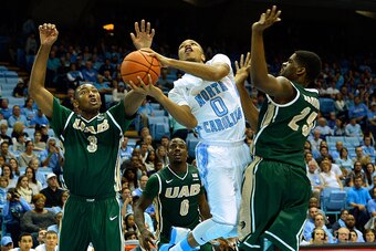 CHAPEL HILL, NC - DECEMBER 27:  Nate Britt #0 of the North Carolina Tar Heels drives between Chris Cokley #3 and C.J. Washington #25 of the UAB Blazers during their game at the Dean Smith Center on December 27, 2014 in Chapel Hill, North Carolina. North C
