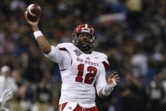 Dec 26, 2014; St. Petersburg, FL, USA; North Carolina State Wolfpack quarterback Jacoby Brissett (12) passes the ball against  the Central Florida Knights during the first half in the 2014 St. Petersburg Bowl at Tropicana Field. Mandatory Credit: Mark Zer