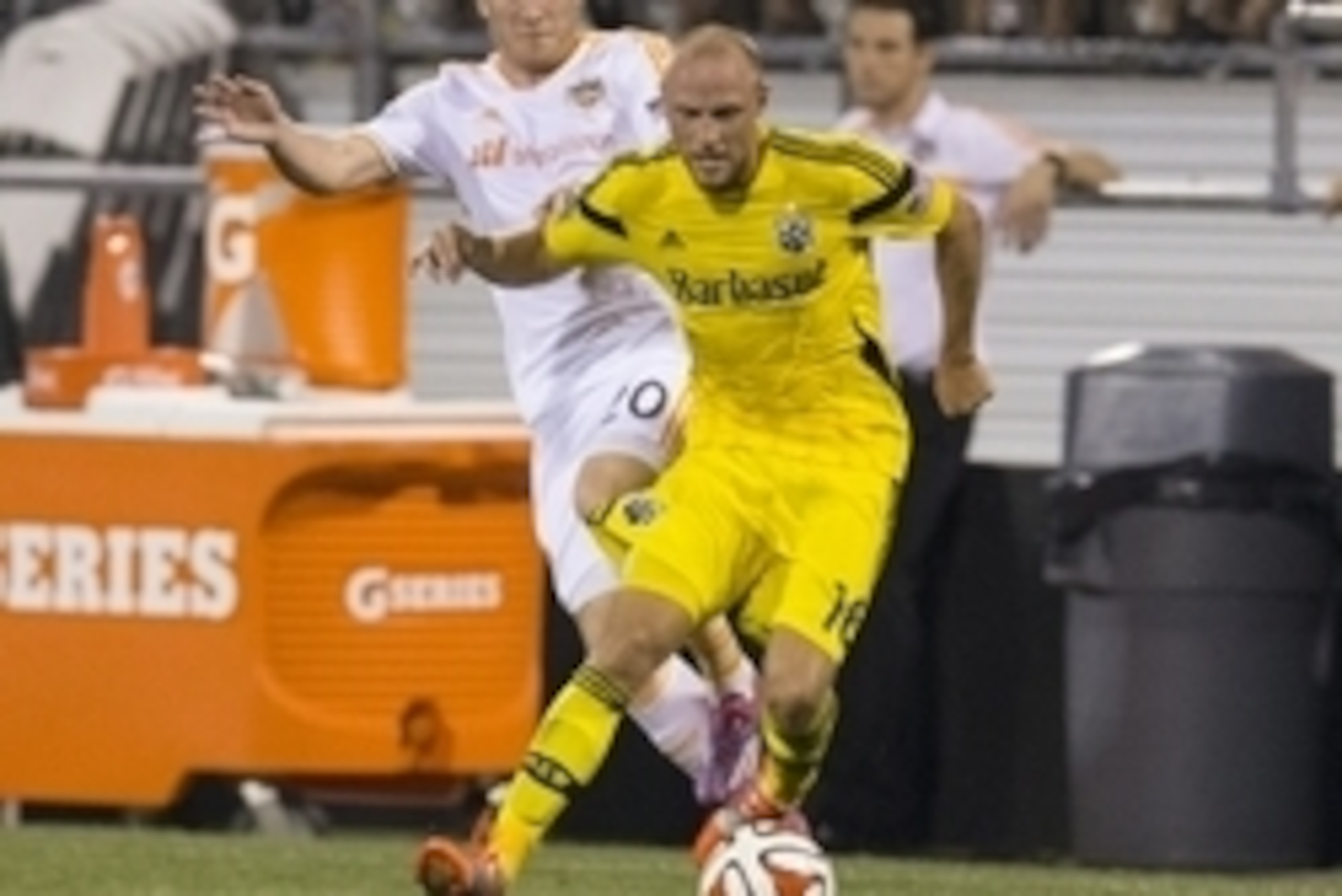 Aug 23, 2014; Columbus, OH, USA; Columbus Crew defender/midfielder Eric Gehrig (16) plays the ball under pressure from Houston Dynamo midfielder Andrew Driver (20) at Crew Stadium. The Crew won 3-0. Mandatory Credit: Greg Bartram-USA TODAY Sports