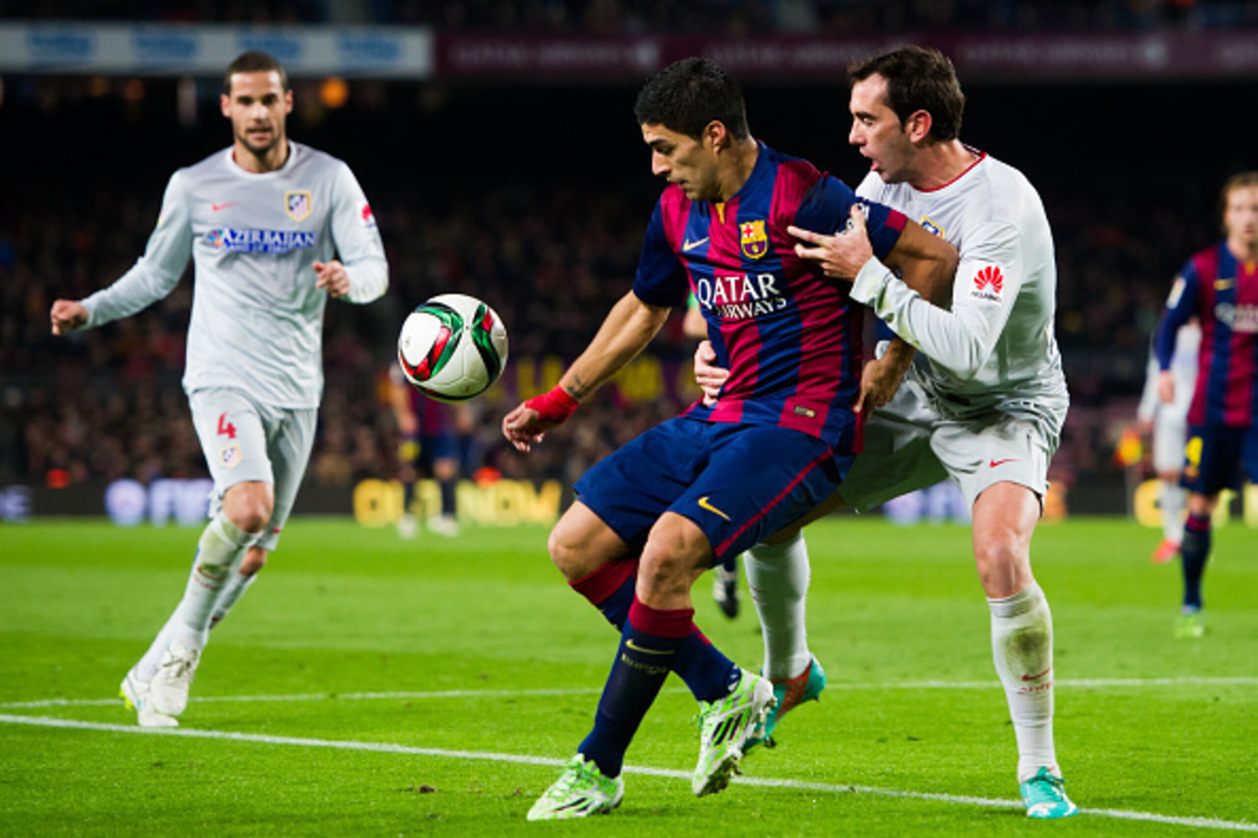 BARCELONA, SPAIN - JANUARY 21:  Luis Suarez of FC Barcelona fights for the ball with Diego Godin of Club Atletico de Madrid during the Copa del Rey Quarter-Final First Leg match between FC Barcelona and Club Atletico de Madrid at Camp Nou on January 21, 2